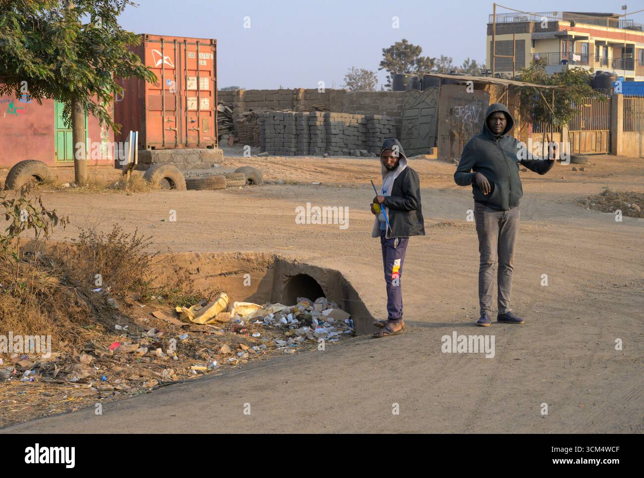 Arbeitslose versammeln sich morgens am Straßenrand und hoffen auf eine gelegentliche Arbeit im Kajiado County, Loitokitok District, Kenia. Stockfoto