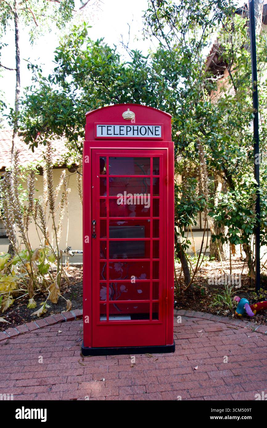 Rote britische Telefonzelle im Garten Stockfoto