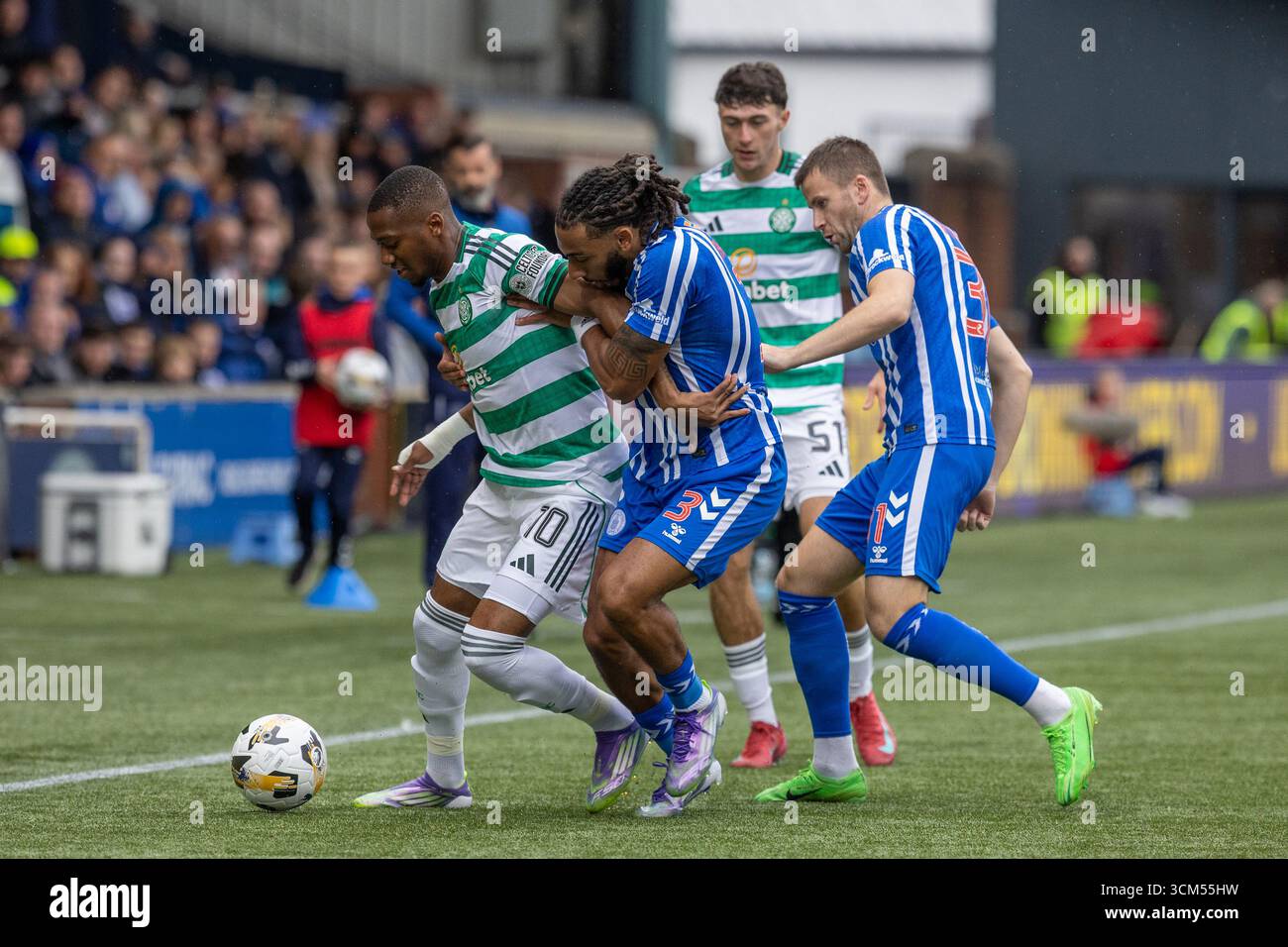 Kilmarnock, Großbritannien. Kilmarnock, Großbritannien. September 2025. Kilmarnock FC spielte Celtic FC im Rugby Park, Kilmarnock, Ayrshire, Schottland in einem William Hill Premiership Spiel. Das Finale war Kilmarnock 1:2 Celtic. Michel-Ange Balikwisha (C10) mit dem Ball wird von Dominic Thompson (K3) und Liam Polworth (K31) angegriffen Stockfoto