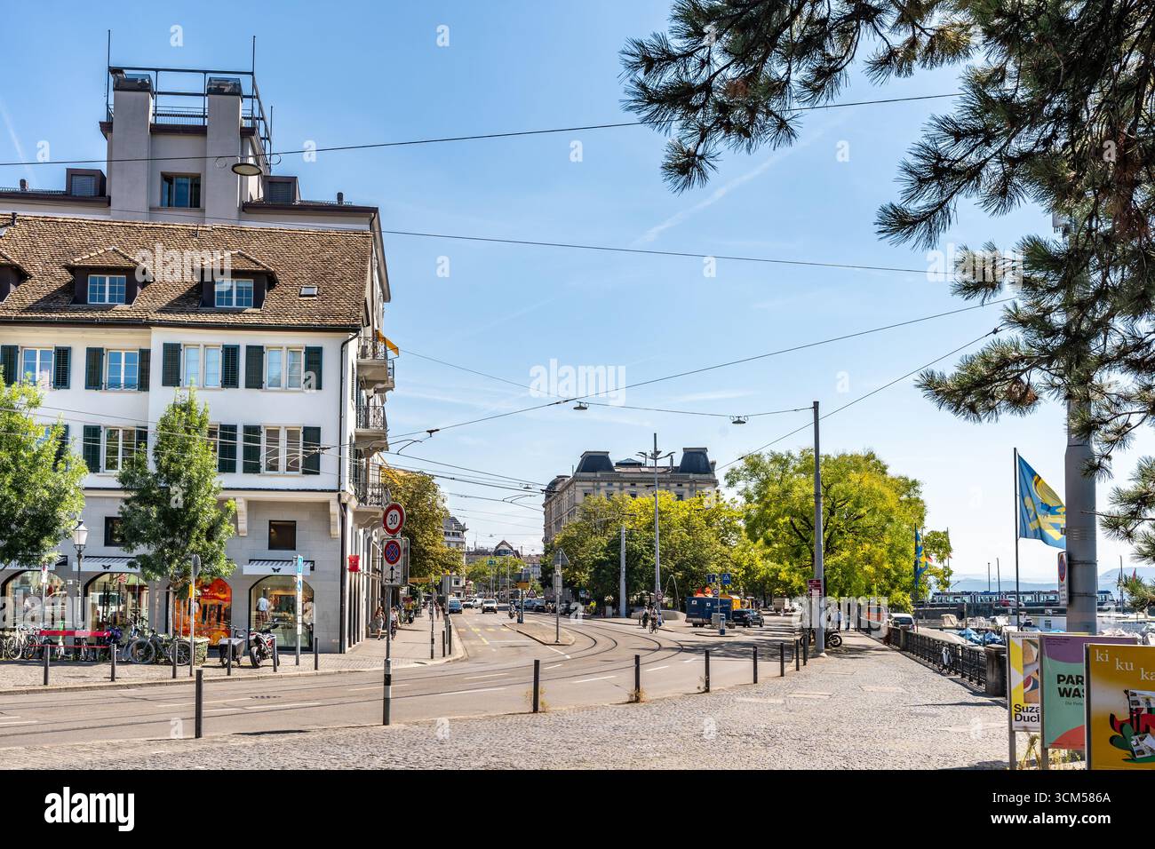 Blick auf Limmatquai vor der gotischen Wasserkirche mit historischen Gebäuden, Bäumen und ruhigen Straßen entlang der Limmat in Zürich Schweiz Stockfoto