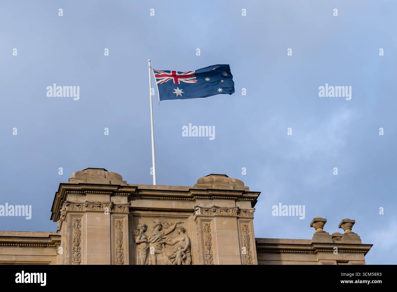 Australische Nationalflagge winkt im Parlamentsgebäude an der Spring Street in Melbourne, Victoria, Australien. Stockfoto