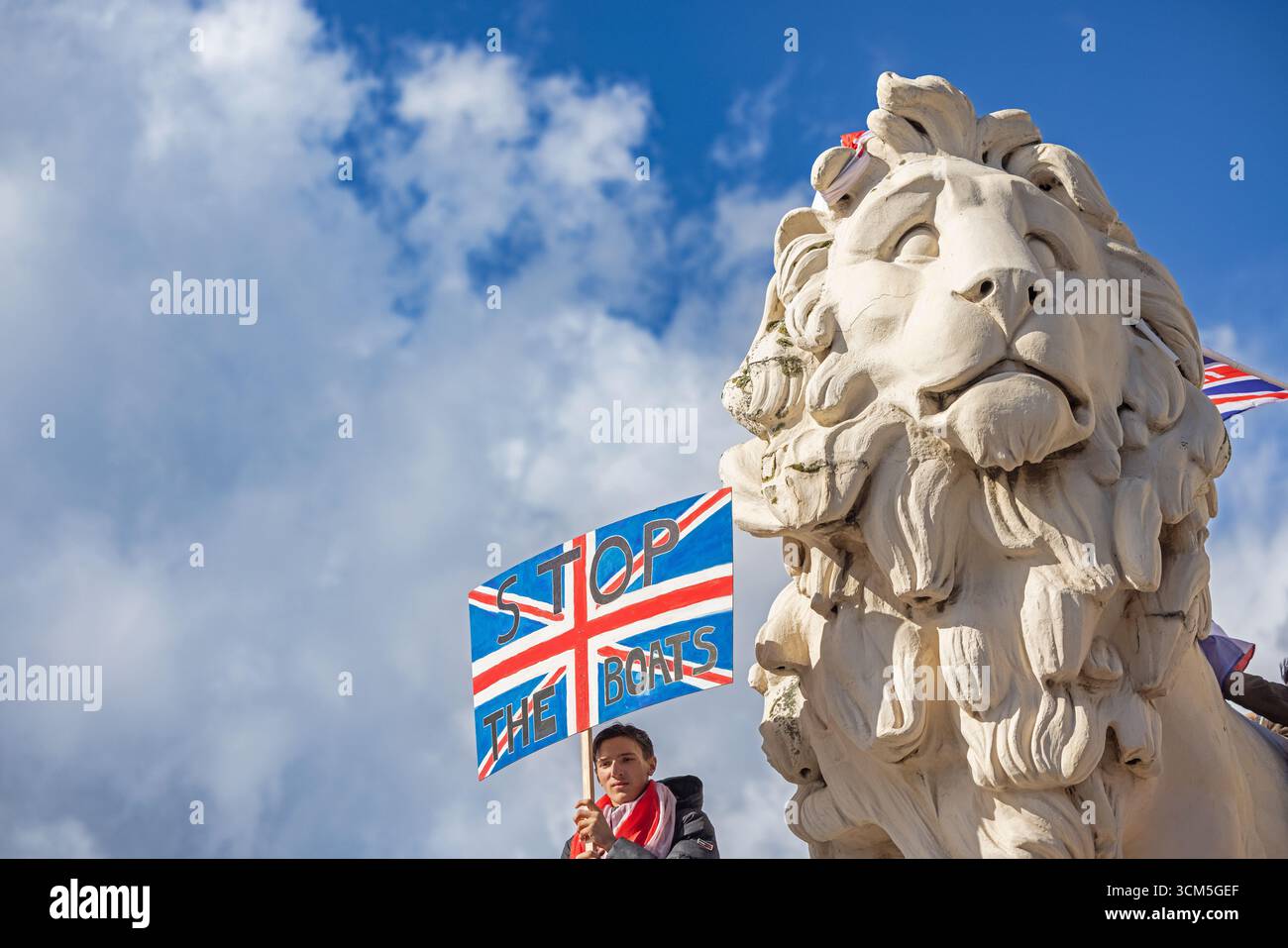 Ein Demonstrant der Unite the Kingdom-Rallye mit einem „Stop the Boats“-Schild während einer politischen Demonstration in London, Großbritannien. Stockfoto