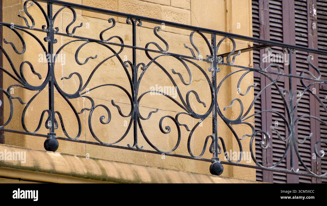 Dekoratives gusseisernes Balkongeländer an einem Haus in San Sebastián mit kompliziertem Design und handwerklichem Können Stockfoto