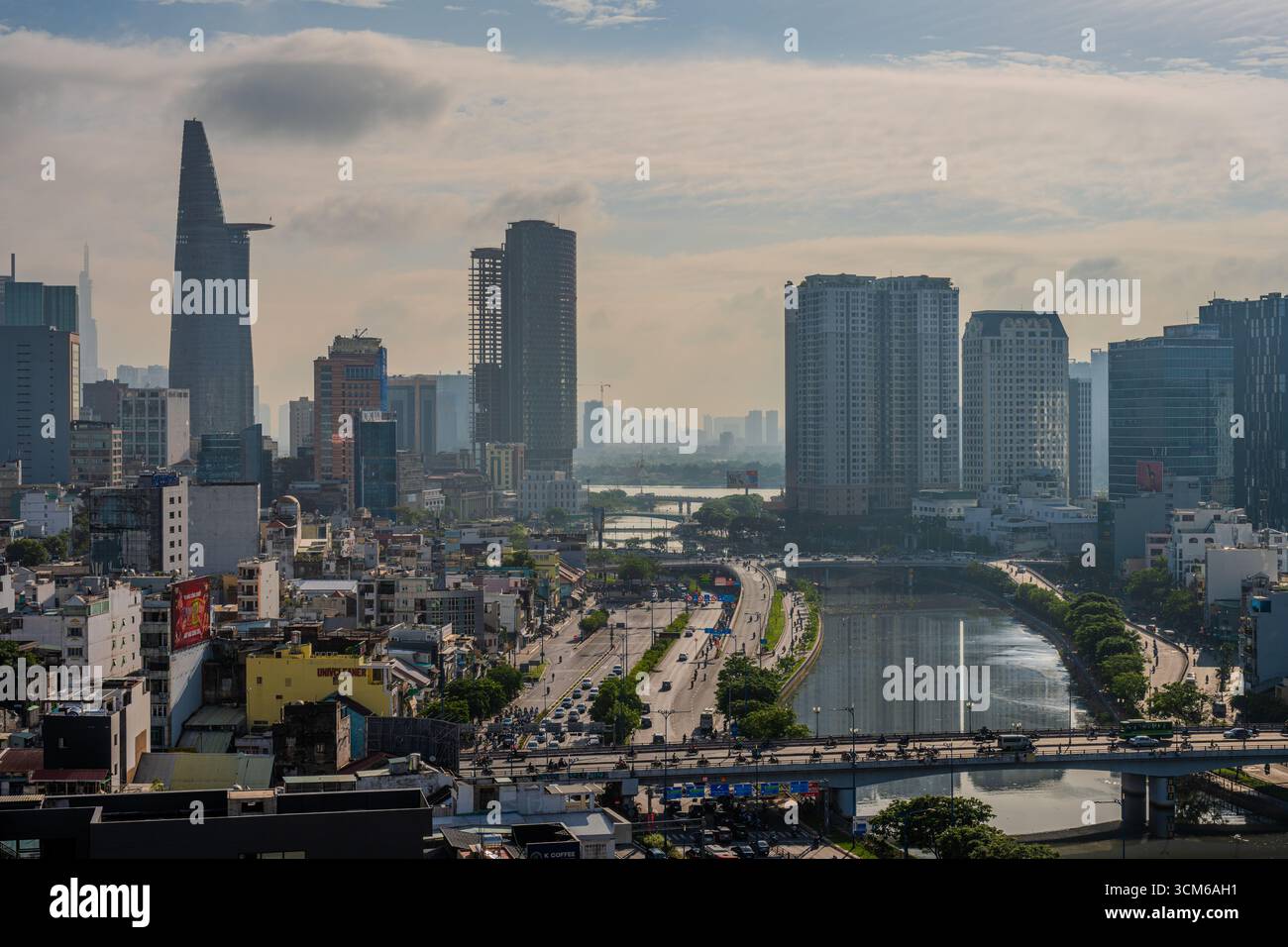 Der Bitexco Financial Tower und die umliegenden Hochhäuser stehen entlang eines Kanals im Zentrum von Ho Chi Minh City, Vietnam. Stockfoto