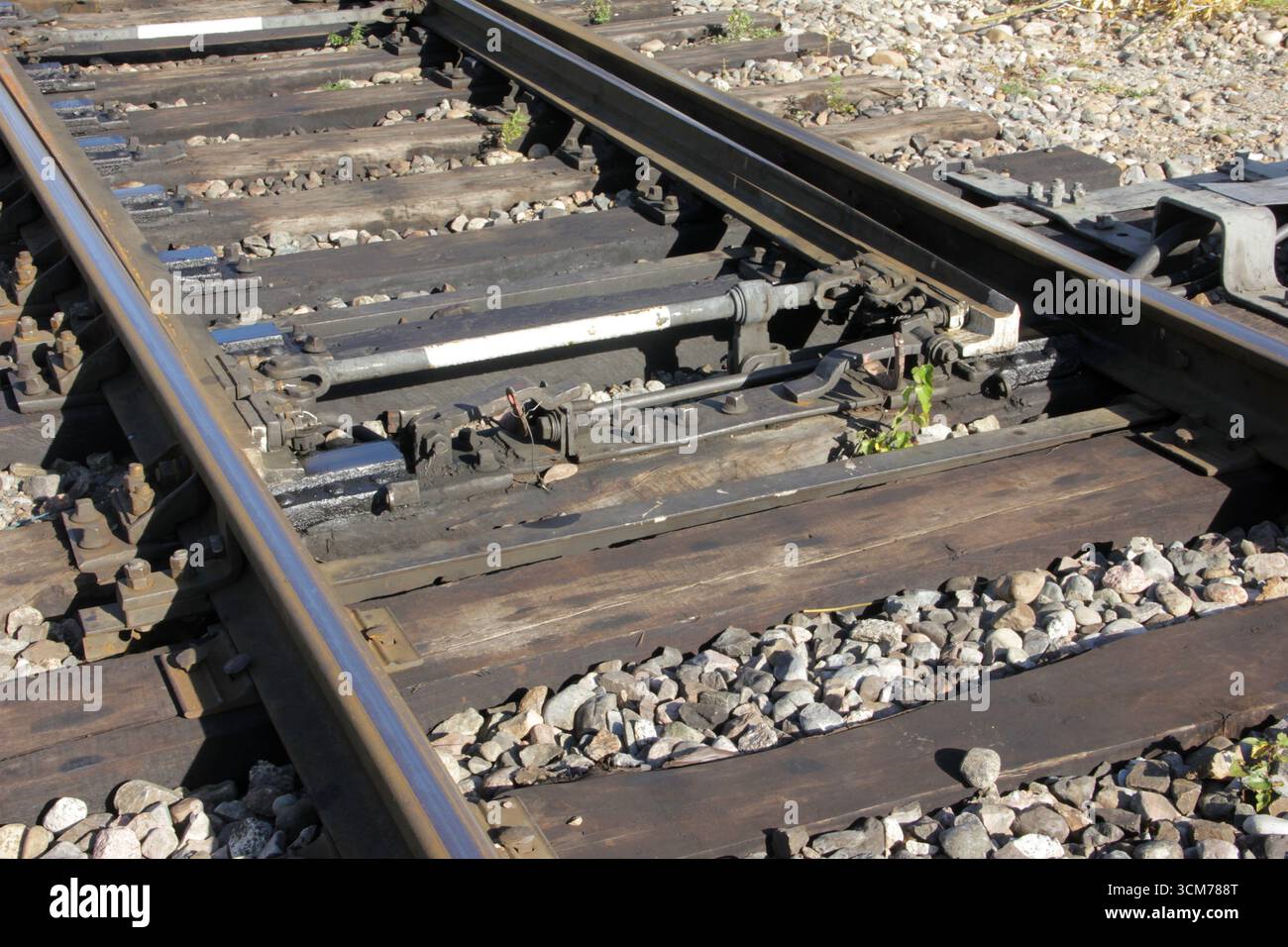 Nahaufnahme einer Schienenverzweigungsanlage, die zwei Gleise miteinander verbindet, wobei die Technik und Infrastruktur der Eisenbahnsysteme hervorgehoben werden Stockfoto