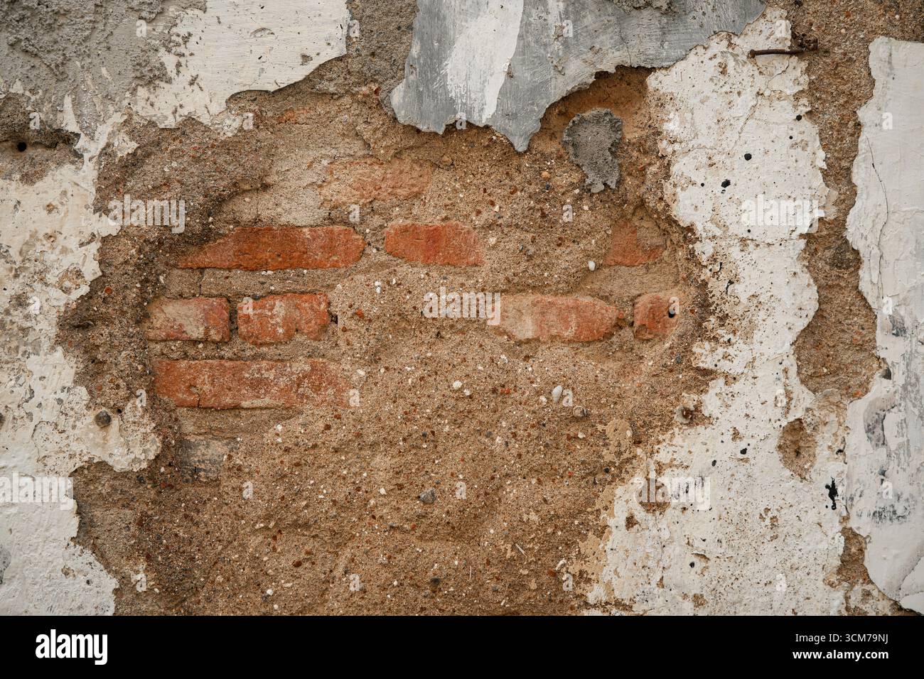 Nahaufnahme einer verwitterten Wand mit freiliegenden Ziegeln und Putz Stockfoto