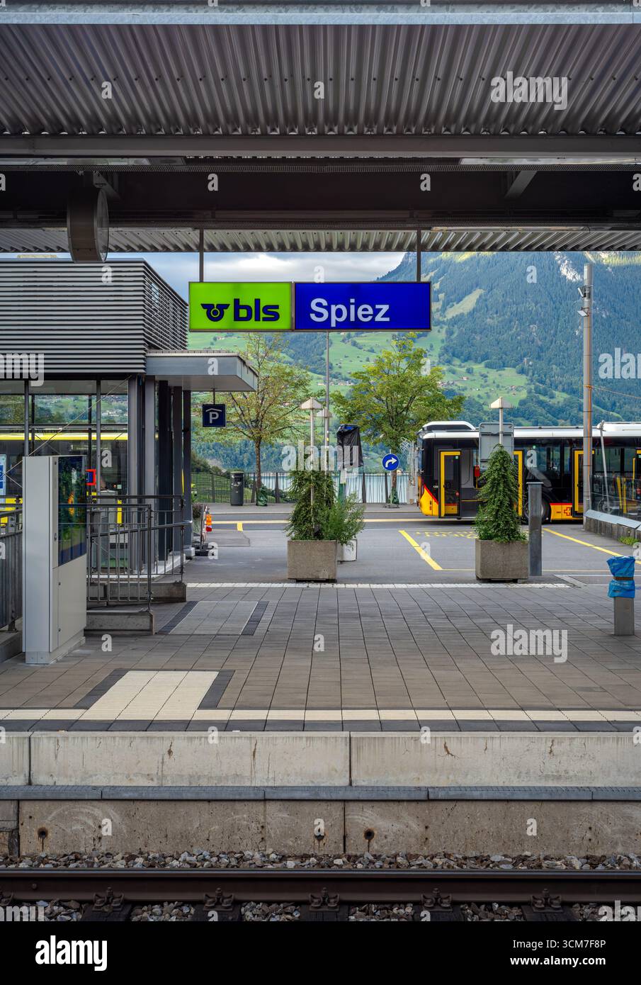 Spiez, Schweiz - 11. September 2025: Bahnsteig mit Schild für Spiez, umgeben von Bergen. Stockfoto