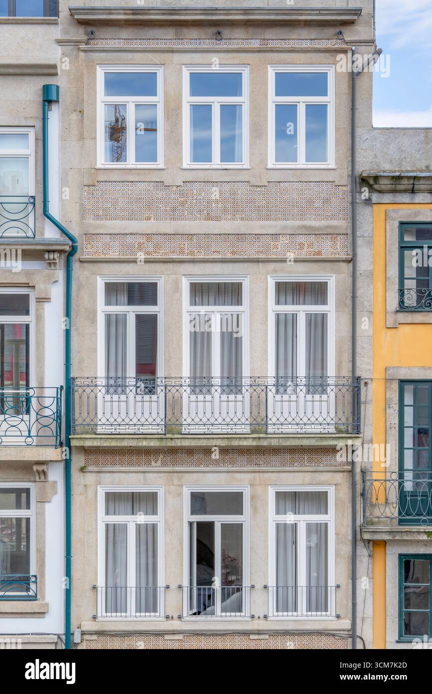 Traditionelles Portugiesisches Gebäude Mit Azulejo-Fliesen Und Weißen Fenstern In Porto. Historische Europäische Architektur, Dekorative Keramikdetails, Balkone Stockfoto