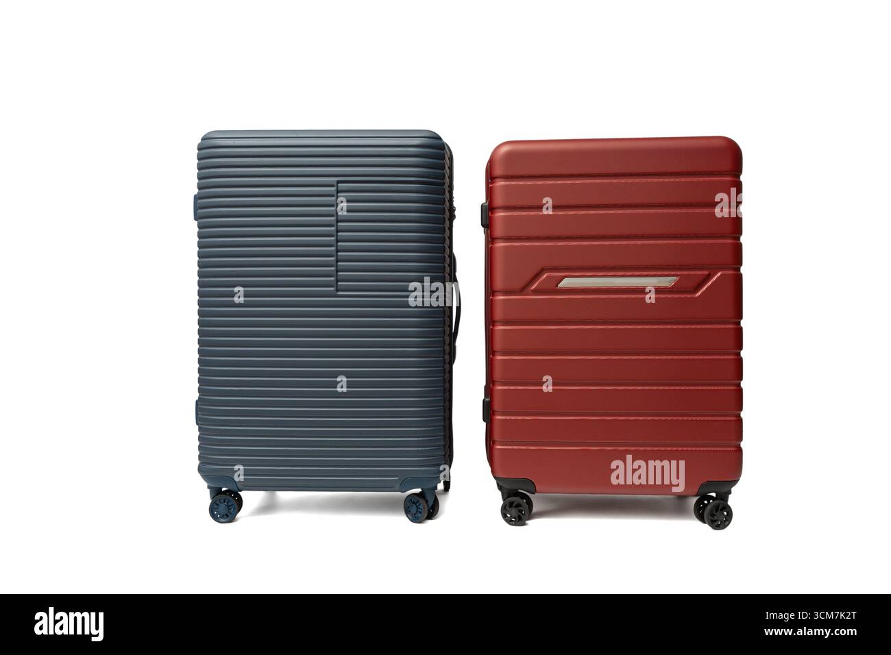 Blaue und rote Hartschalenkoffer nebeneinander. Modernes Reisedesign mit Strapazierfähigkeit und Style. Reisekoffer isoliert auf weißem Hintergrund. Stockfoto
