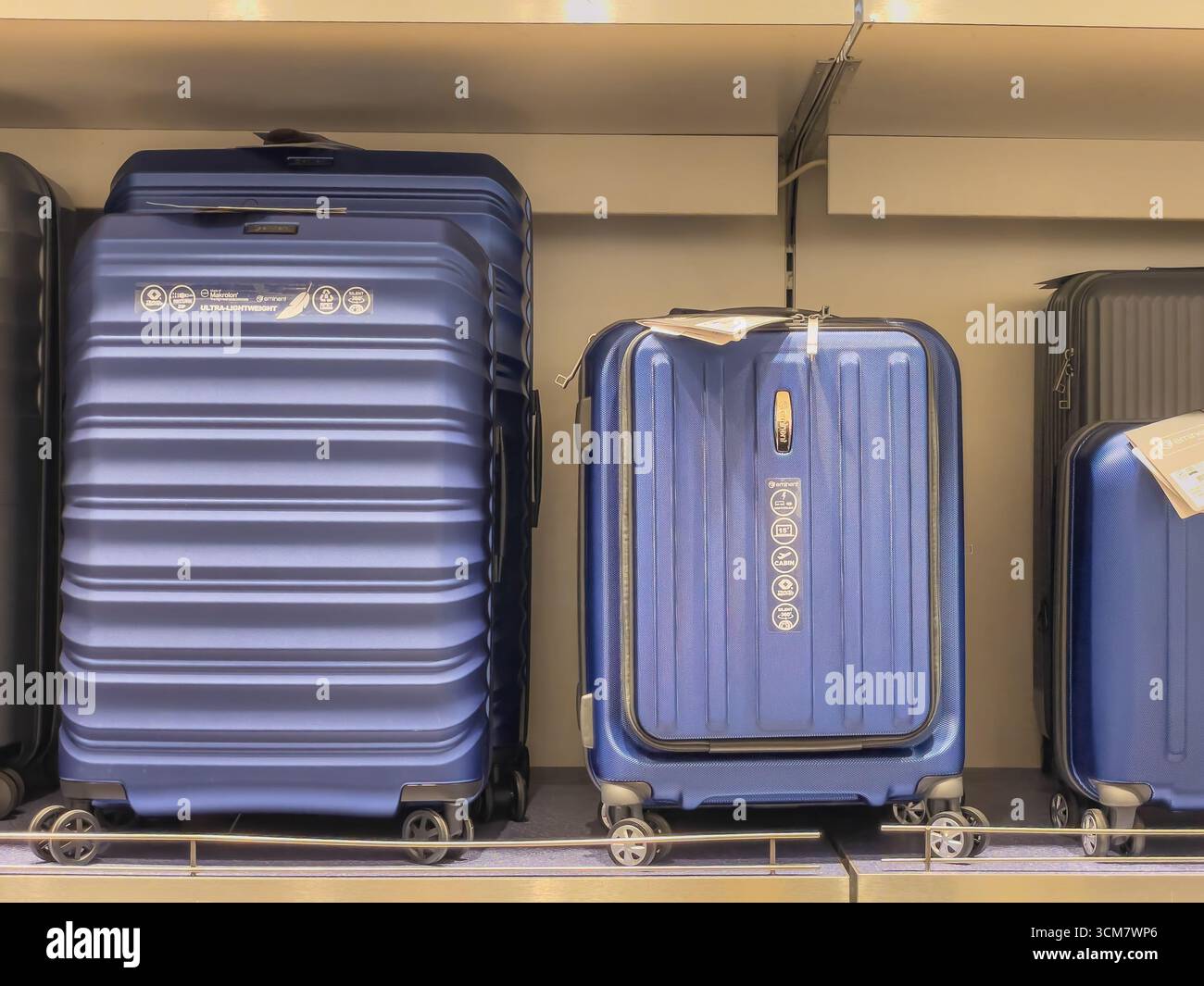 Deutschland Berlin 09.13.2025. Zwei große blaue Hartschalenkoffer auf einem Regal, ultraleicht und robust. Perfekt für Reisen. Stockfoto