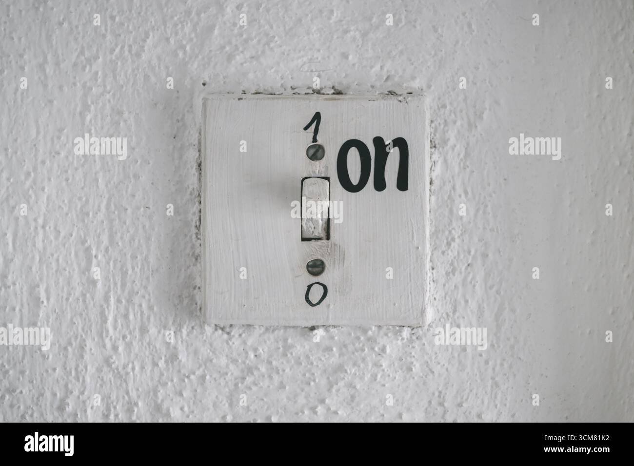 Alter Vintage rustikaler Lichtschalter an der Wand mit Zahlen 1 für ein und 0 für aus, symbolisiert Kontrolle, Auswahl, Entscheidung, Leistung, und Vintage-Industrieheri Stockfoto