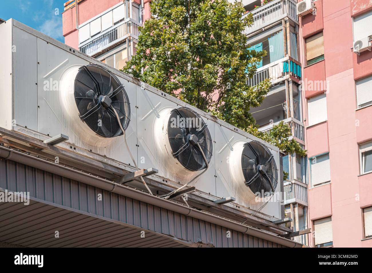 Große Klimaanlagen im Freien mit Industrielüftern, die auf einem Gebäude in der Stadt montiert sind. Selektiver Fokus. Stockfoto
