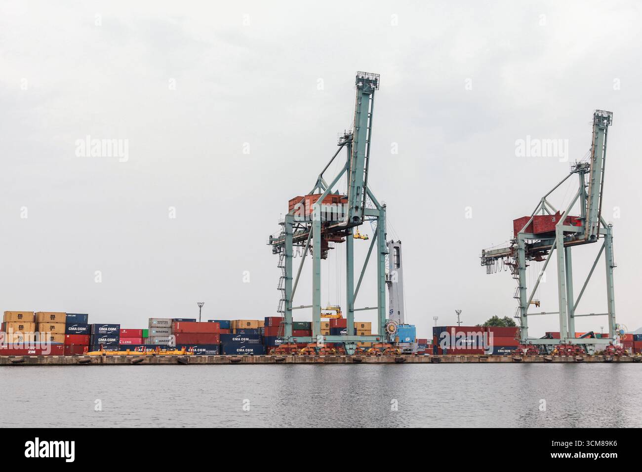 Varna, Bulgarien - 16. Juli 2014: Ein Schiffshafen mit Kränen, die Container auf Stapeln im ruhigen Wasser abladen. Ein geschäftiges internationales Drehkreuz mit m Stockfoto