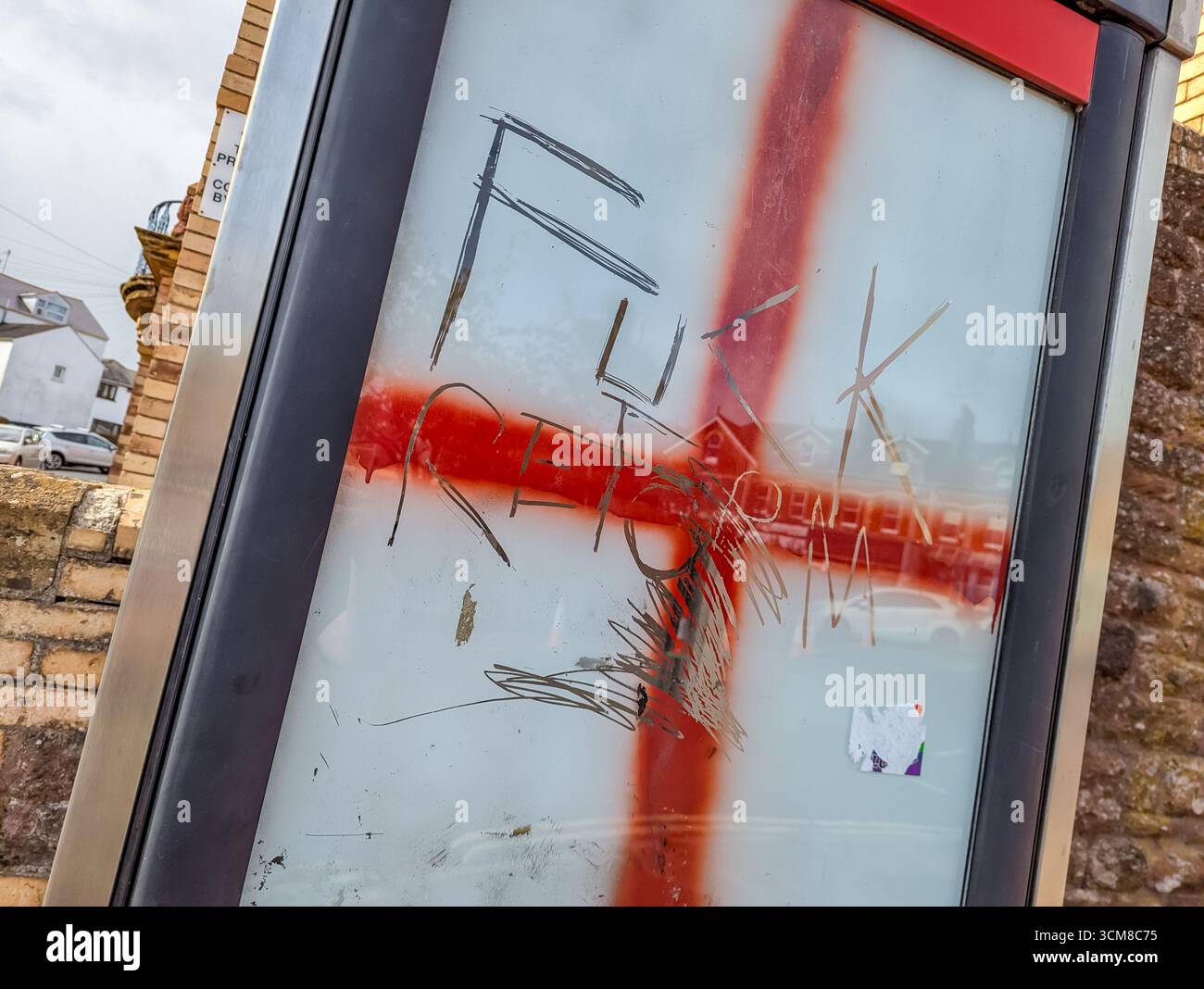 Paignton, Großbritannien. September 2025. Traditionelle rote Telefonbox mit Fenstern, die mit Graffiti der rot-weißen Flagge von St. George, der Nationalflagge Englands, bedeckt sind. Autor: Thomas Faull/Alamy Live News Stockfoto