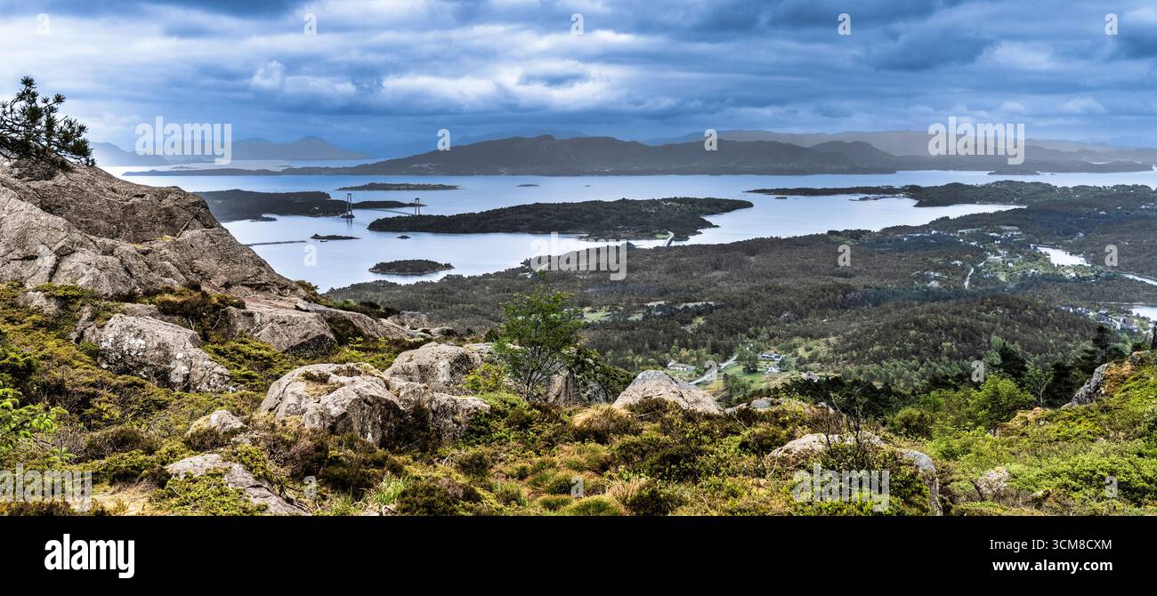 Eine malerische Landschaft mit einem Panoramablick auf üppige Hügel, ruhige Seen und verstreute Inseln unter einem dramatischen bewölkten Himmel, die essen einfangen Stockfoto