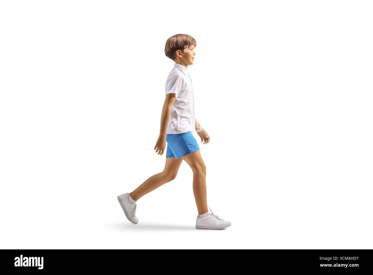 Profilaufnahme eines Jungen in weißem T-Shirt und blauen Shorts, der isoliert auf weißem Hintergrund läuft Stockfoto