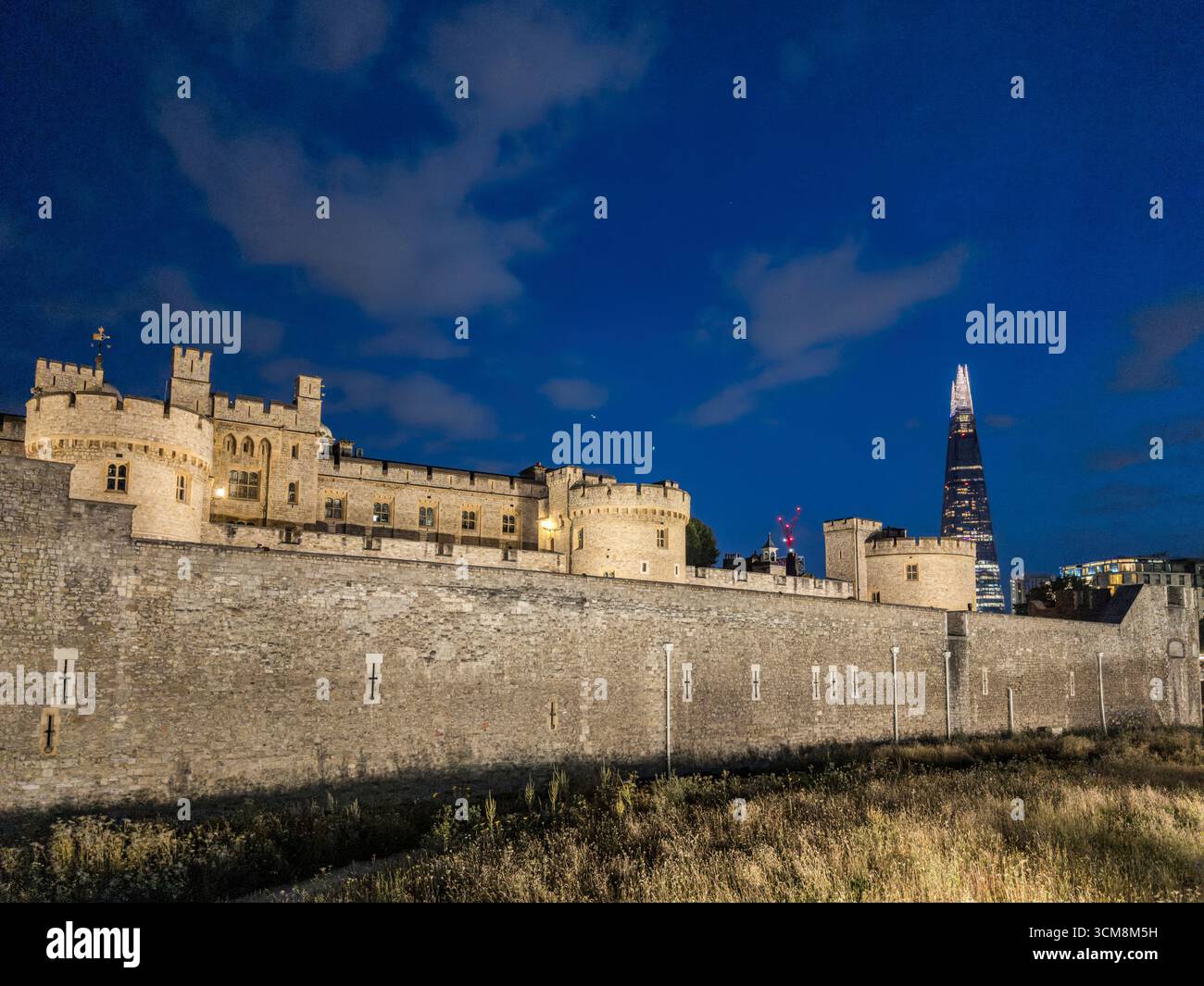 Tower of London bei Nacht, im Hintergrund der moderne Wolkenkratzer The Shard in London, England. Stockfoto