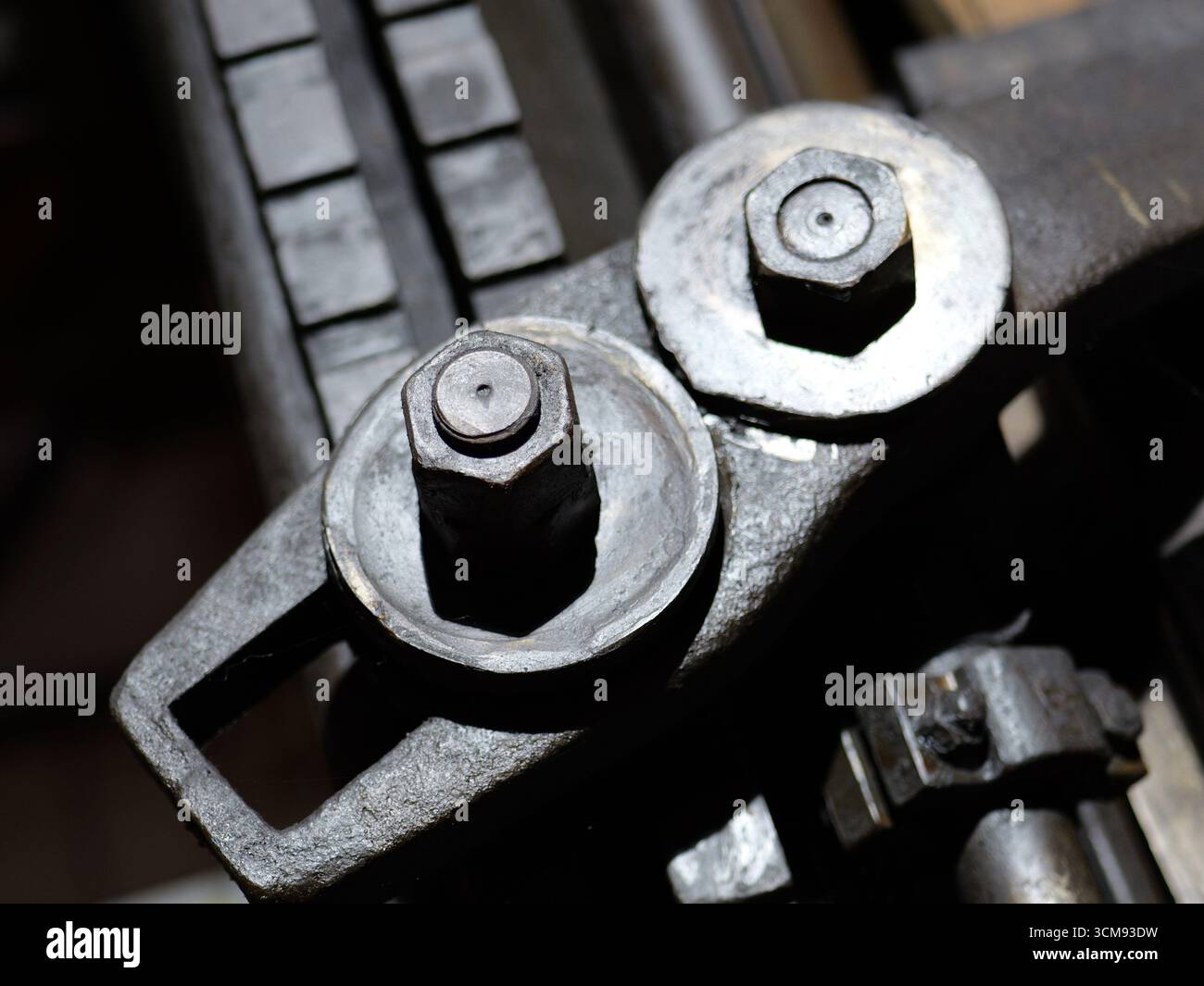 Alte Bolzen und Schrauben am historischen Maschinenteil mit Patina und Verschleiß. Kopierraum. Stockfoto