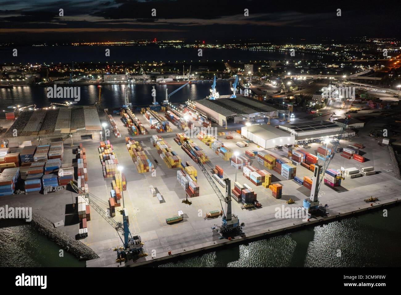 Luftaufnahme zu einem Container-Entladeterminal des Hafens von Burgas, Bulgarien bei Nacht. Logistik und Transport Stockfoto