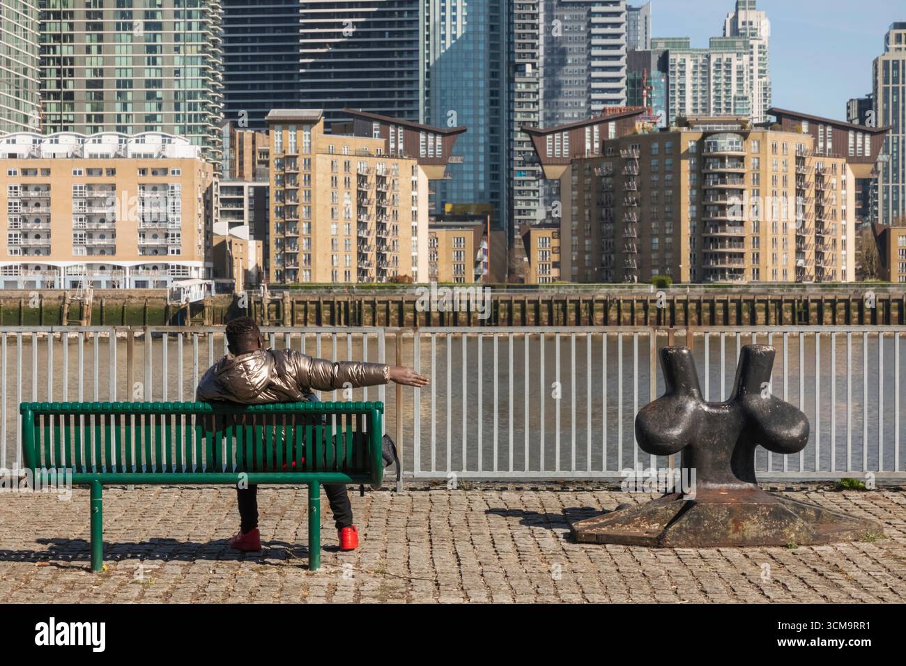 England, London, Docklands, die Themse und die Skyline von Canary Wharf, ein entspannender Mann am Riverside Stockfoto