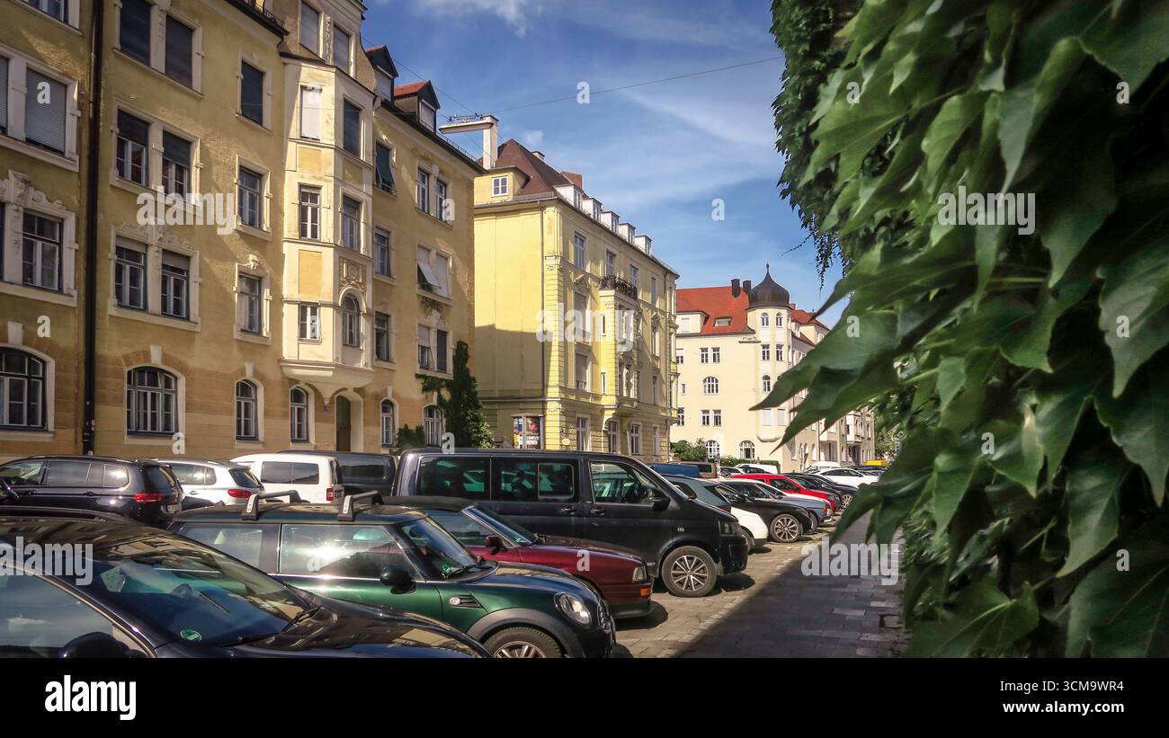 Typische Straße in München Schwabing. Vierstöckiges Neorenaissance-Gebäude mit Mittelachse, die durch Erkerfenster und Zwerghaus, Gipsstruktur und Stuckverzierungen unterstrichen wird. Baujahr 1902. Stockfoto