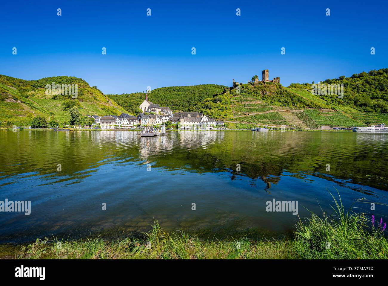 Beilstein an der Mosel in Rheinland-Pfalz, ein malerisches Dorf, das „Dornröschen“ der Mosel oder „Miniatur-Rothenburg“ genannt wird, Blick auf die Moselpromenade, die Ruine von Schloss Metternich oben rechts auf dem Hügel Stockfoto