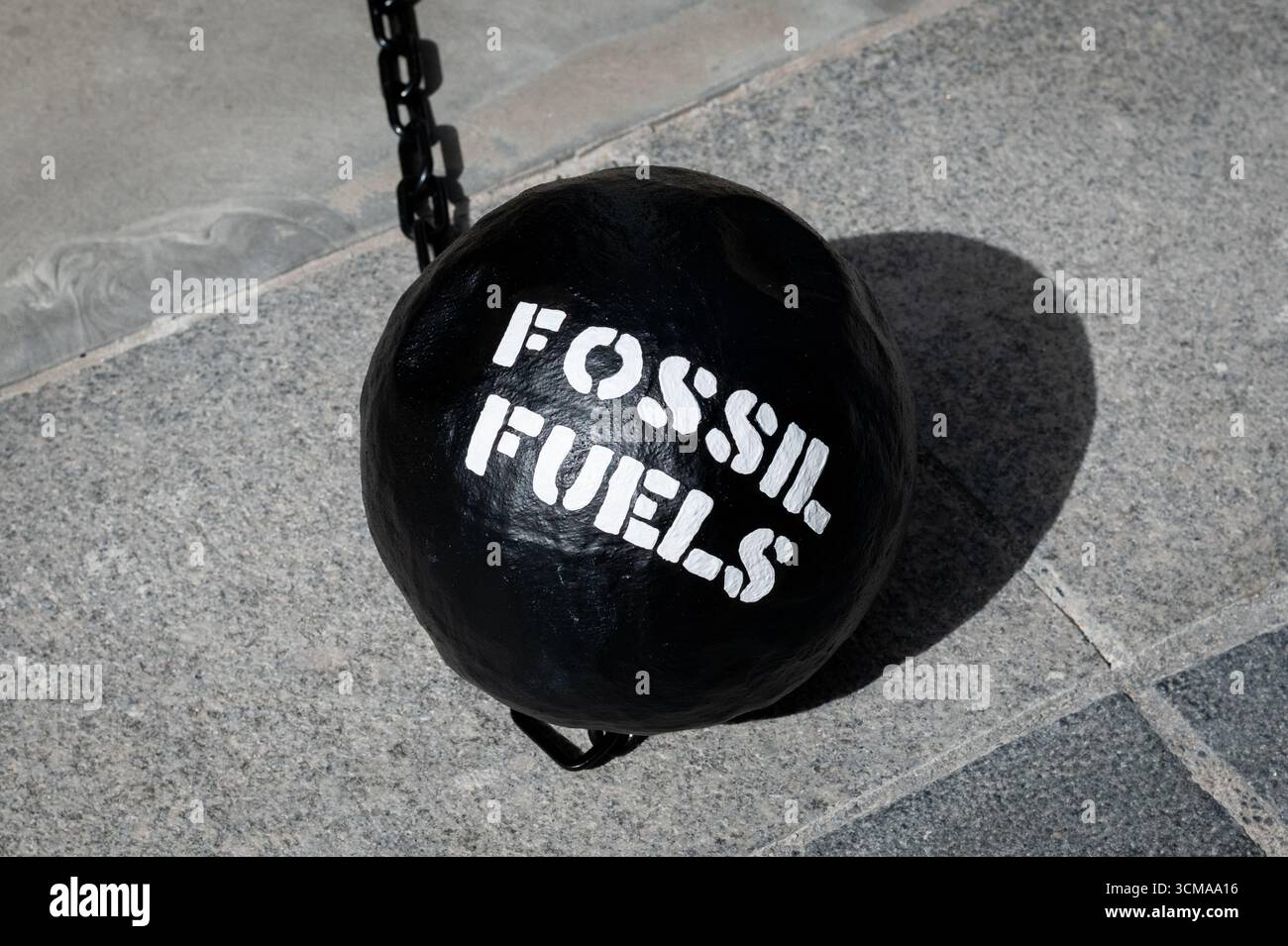 London, Großbritannien. 15. September 2025. Ein Ball und eine Kette mit der Bezeichnung „fossile Brennstoffe“ sitzt auf dem Boden, während Klimaaktivisten vor dem Hauptsitz des Fondsmanagers BlackRock im Finanzviertel Londons einen theatralischen Protest veranstalten, in dem sie sie auffordern, angesichts einer Klimakrise die Verbindungen zur fossilen Brennstoffindustrie abzubauen. Quelle: Ron Fassbender/Alamy Live News Stockfoto