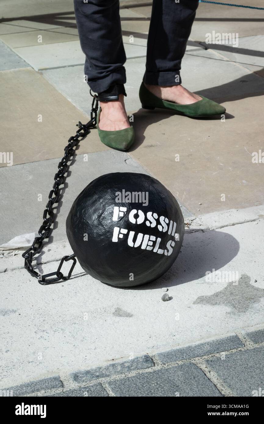 London, Großbritannien. 15. September 2025. Ein Ball und eine Kette mit der Aufschrift "fossile Brennstoffe" sind am Bein eines Demonstranten befestigt, der als Kanzlerin Rachel Reeves verkleidet ist, während Klimaaktivisten vor dem Hauptsitz des Fondsmanagers BlackRock im Londoner Finanzviertel einen theatralischen Protest veranstalten und sie auffordern, angesichts einer Klimakrise die Verbindungen zur fossilen Brennstoffindustrie abzubauen. Quelle: Ron Fassbender/Alamy Live News Stockfoto