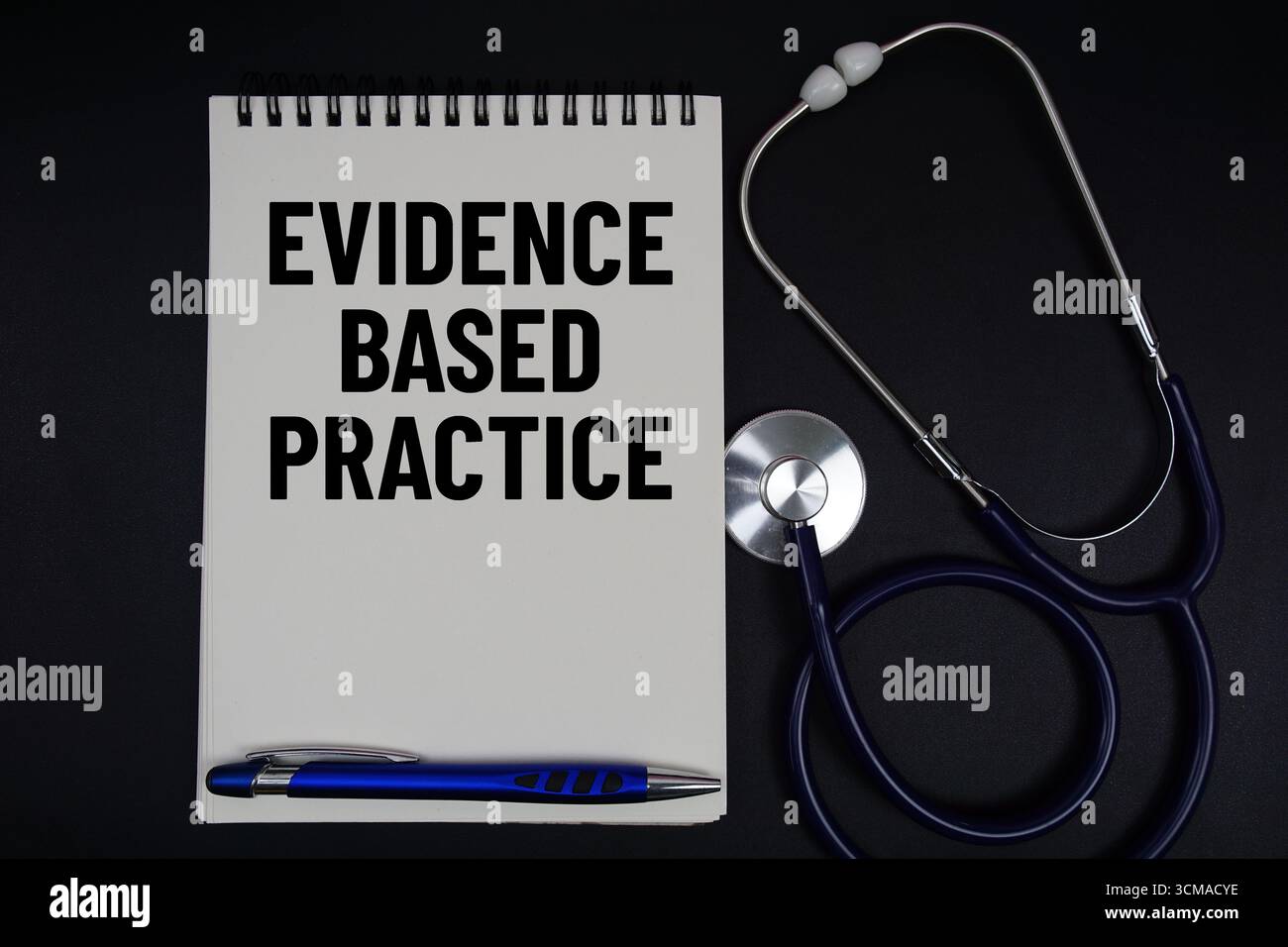 Notizblock mit „evidenzbasierter Praxis“, Stift, Hammer und Stethoskop auf schwarzem Hintergrund Stockfoto