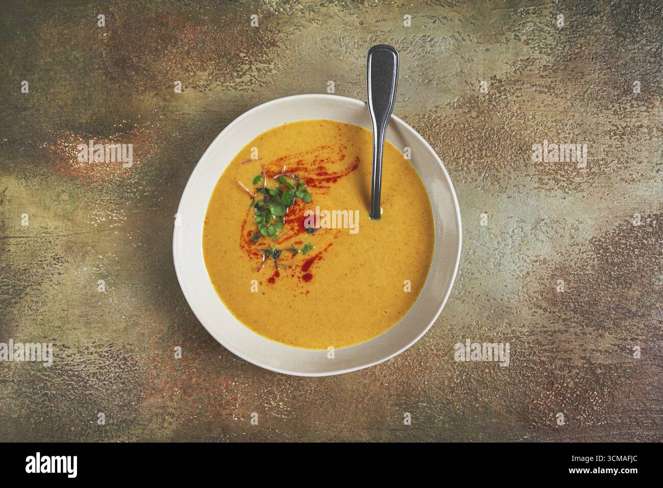 Kürbiscremesuppe, in einer weißen Schüssel auf strukturiertem Hintergrund, Blick von oben, hausgemacht, keine Leute, rustikaler Stil Stockfoto