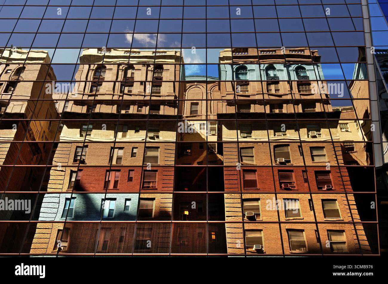 Wohngebäude spiegeln sich in einer Hochhausfassade wider, New York City, USA Stockfoto