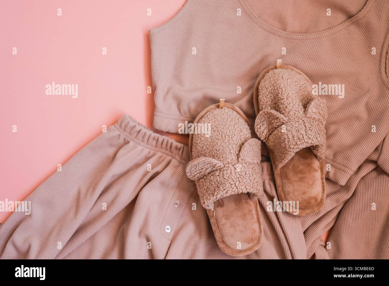 Hausgemachte pinkfarbene Hausschuhe und Pyjama mit Blick von oben Stockfoto