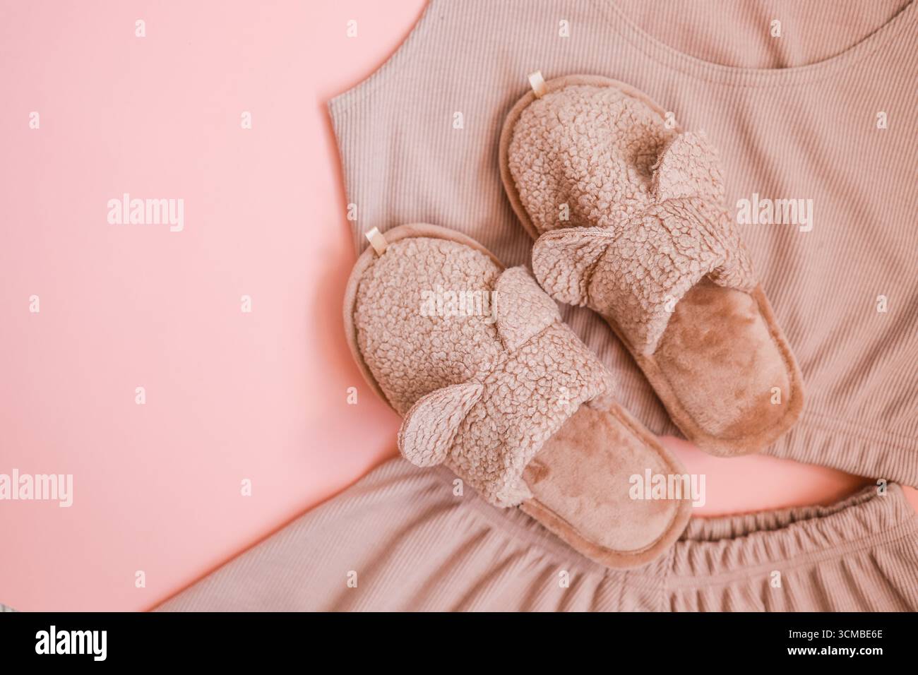 Hausgemachte pinkfarbene Hausschuhe und Pyjama mit Blick von oben Stockfoto