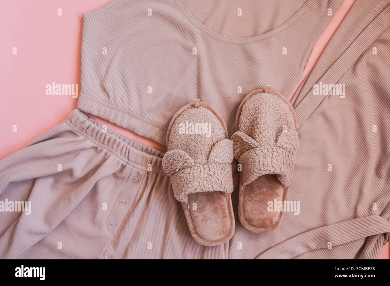 Hausgemachte pinkfarbene Hausschuhe und Pyjama mit Blick von oben Stockfoto