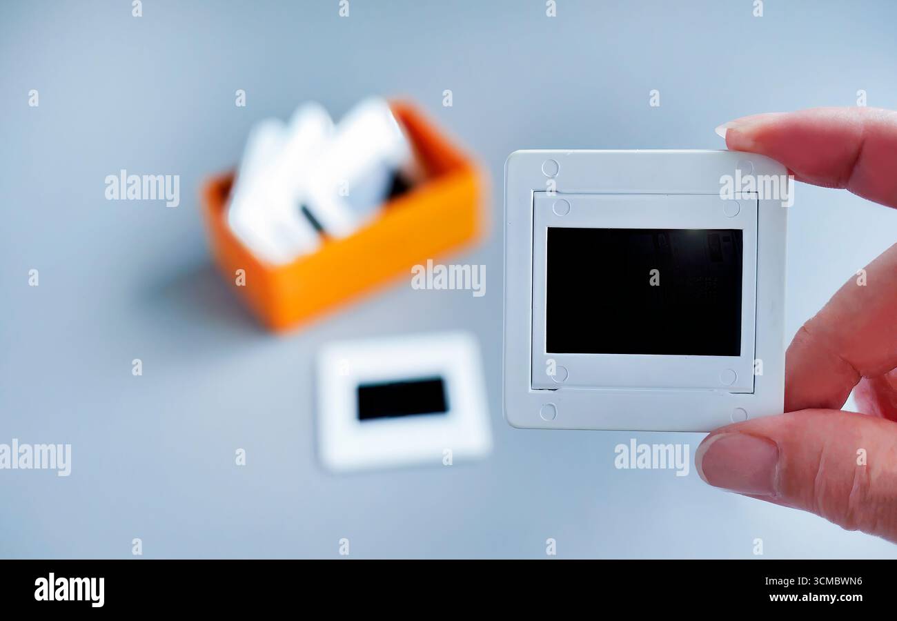 Weiße Kunststoffschienenhalterung für Folienfolie in orangefarbener Kunststoffbox mit einfachem Hintergrund, Retro-Nostalgie, Foto Stockfoto