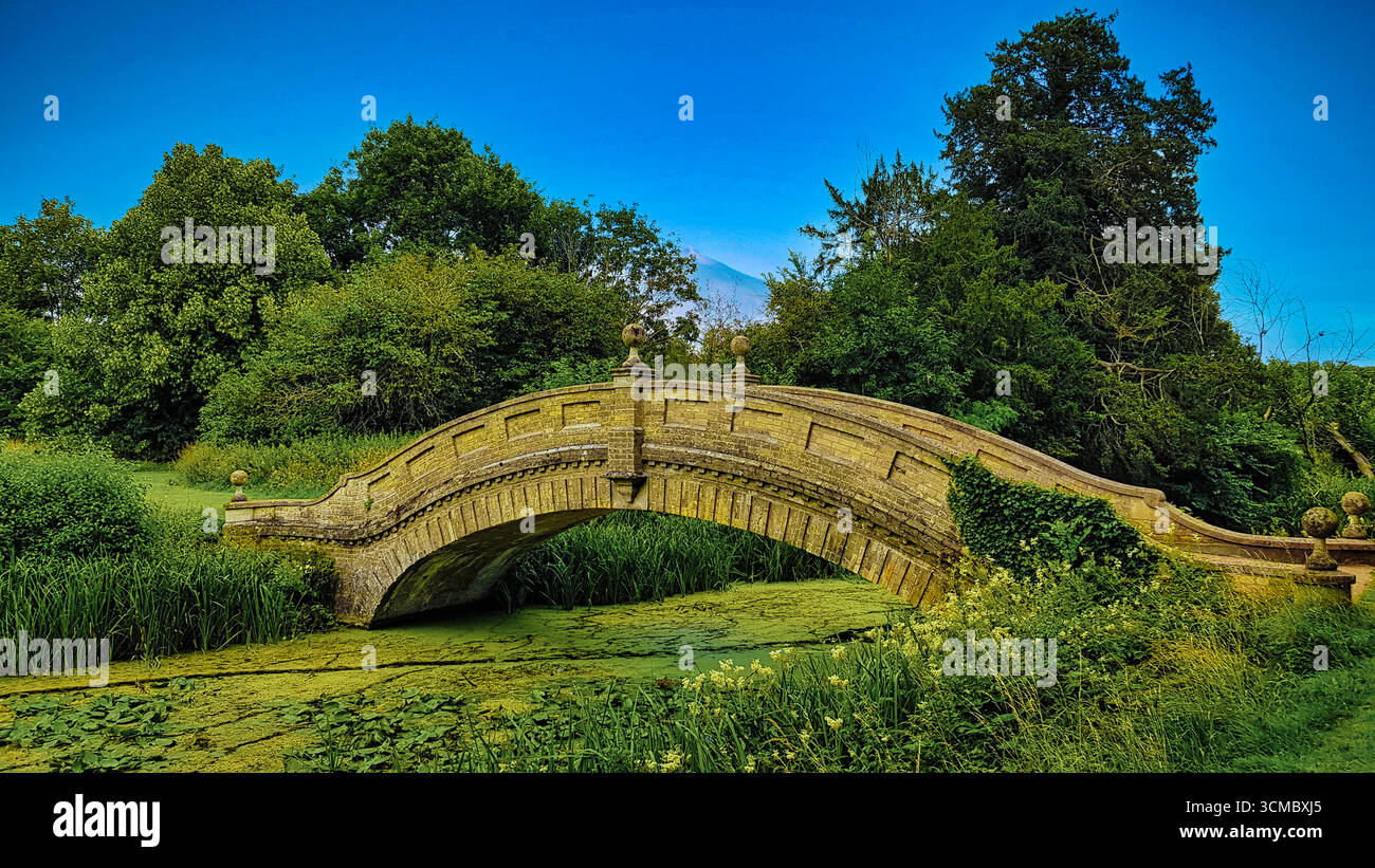 Wrest Park, Silsoe, Bedfordshire; französisches Herrenhaus im Stil eines Schlosses mit formellen Gärten, langem Wasserkanal, Statuen und barockem Pavillon bei Sonnenuntergang. Stock Vektor