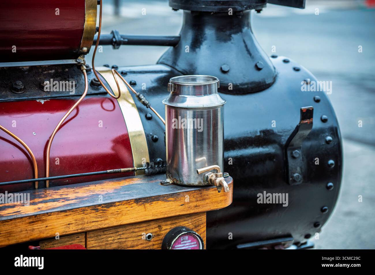 Nahaufnahme der Dampflokomotive mit Messingölkanne, roter und schwarzer Farbe und hölzernem Trittbrett bei der Parade. Stockfoto