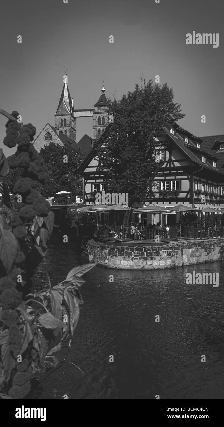 Wunderschöne Landschaft in Esslingen bei Stuttgart, wo ein Fluss an einem Restaurant vorbeifließt und im Hintergrund ein alter Kirchturm zu sehen ist Stockfoto Wunderschöne Landschaft in Esslingen bei Stuttgart, wo ein Fluss an einem Restaurant vorbeifließt und im Hintergrund ein alter Kirchturm zu sehen ist Stockfoto