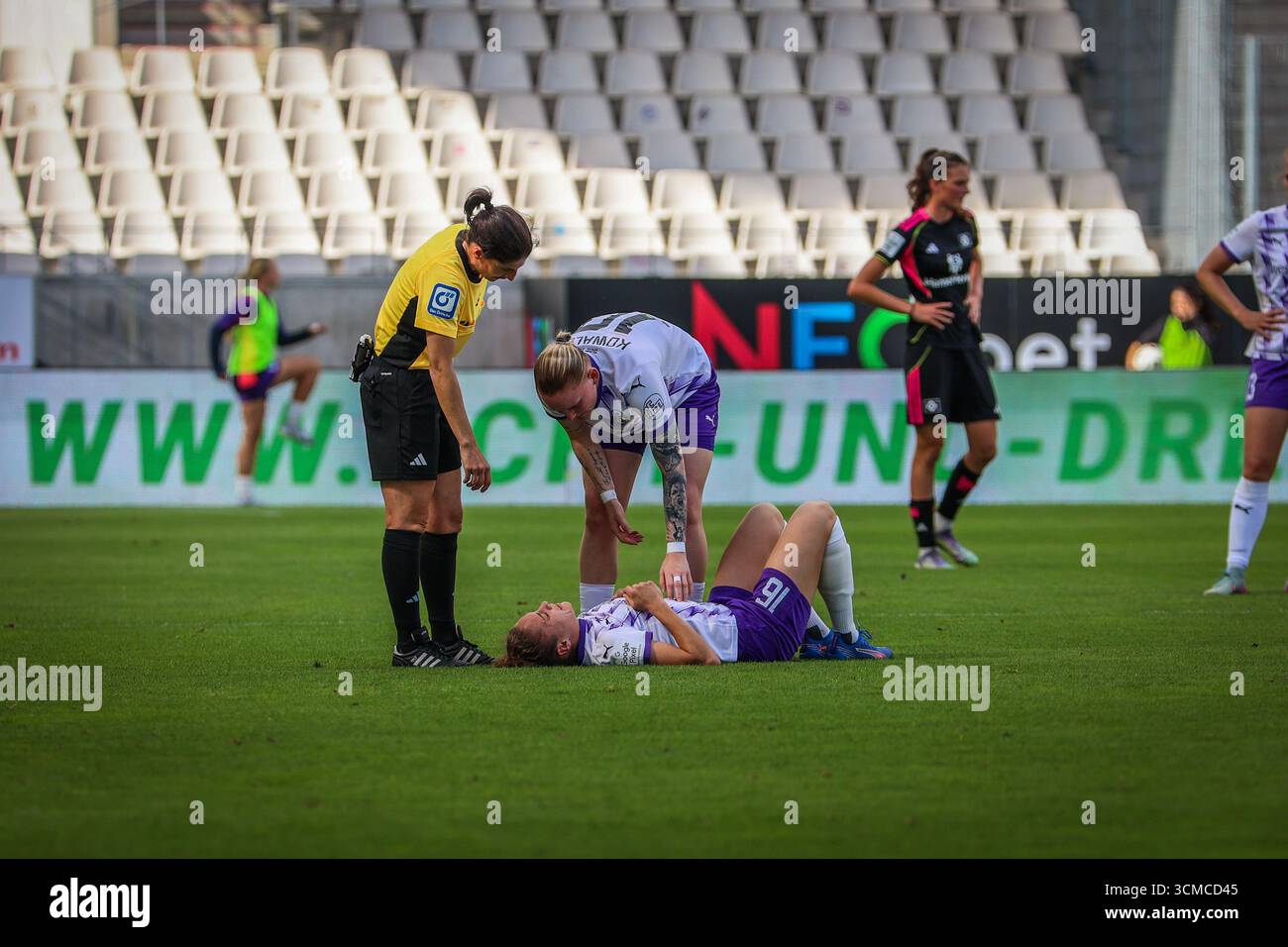 Essen, Deutschland. September 2025. Essen, Deutschland 13. September 2025: 1. BL - Frauen - 2025/2026 - SGS Essen vs. Hamburger SV im Bild: Jaqueline Meißner/Meissner (SGS) liegt verletzt auf dem Spielfeld. Natasha Kowalski (SGS) Schiedsrichterin Riem Hussein (Bad Harzburg) kümmert sich um sie. /// DFB-Vorschriften verbieten die Verwendung von Fotos als Bildsequenzen und/oder Quasi-Video /// Credit: dpa/Alamy Live News Stockfoto