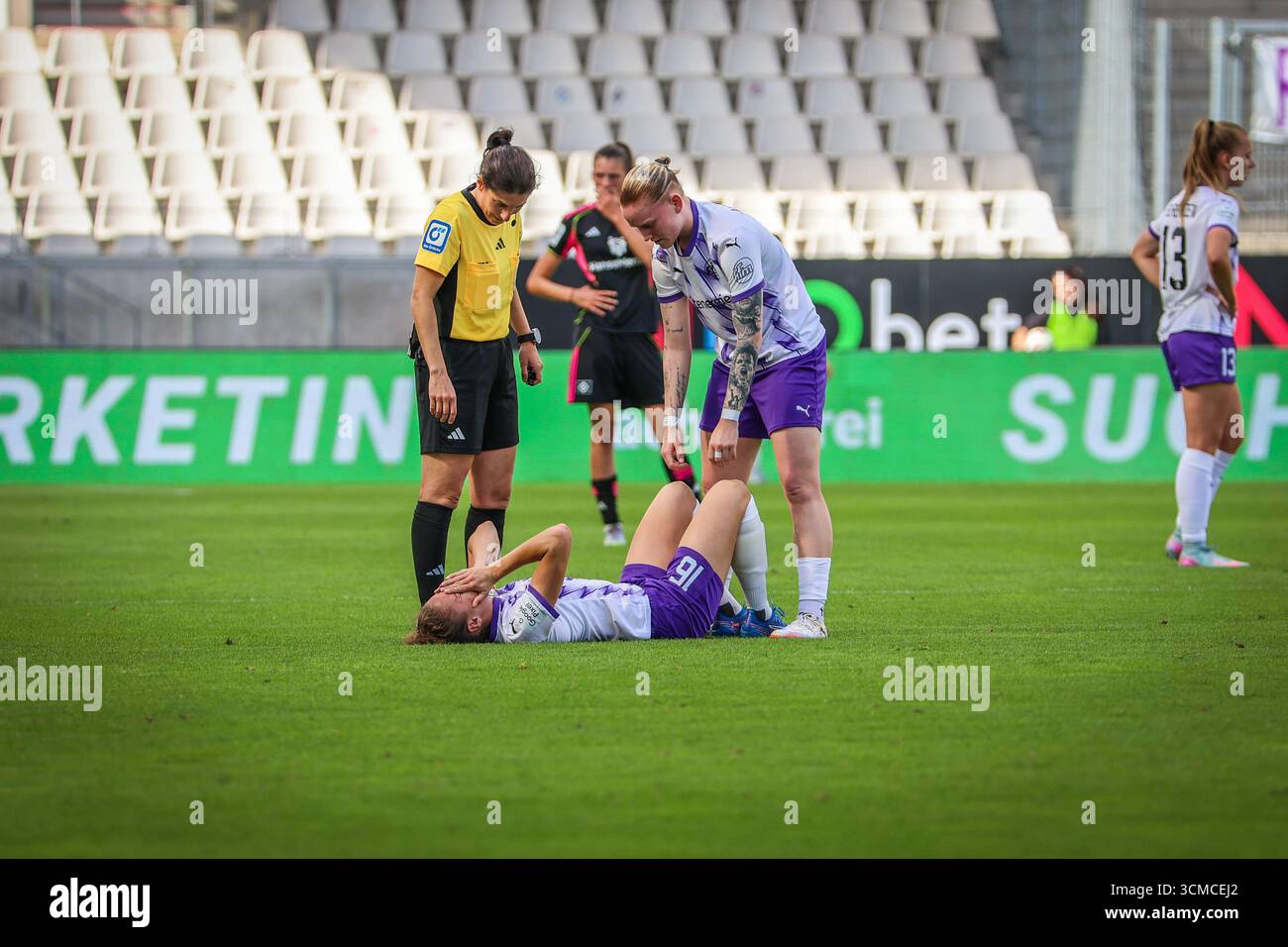 Essen, Deutschland. September 2025. Essen, Deutschland 13. September 2025: 1. BL - Frauen - 2025/2026 - SGS Essen vs. Hamburger SV im Bild: Jaqueline Meißner/Meissner (SGS) liegt verletzt auf dem Spielfeld. Natasha Kowalski (SGS) Schiedsrichterin Riem Hussein (Bad Harzburg) kümmert sich um sie. /// DFB-Vorschriften verbieten die Verwendung von Fotos als Bildsequenzen und/oder Quasi-Video /// Credit: dpa/Alamy Live News Stockfoto