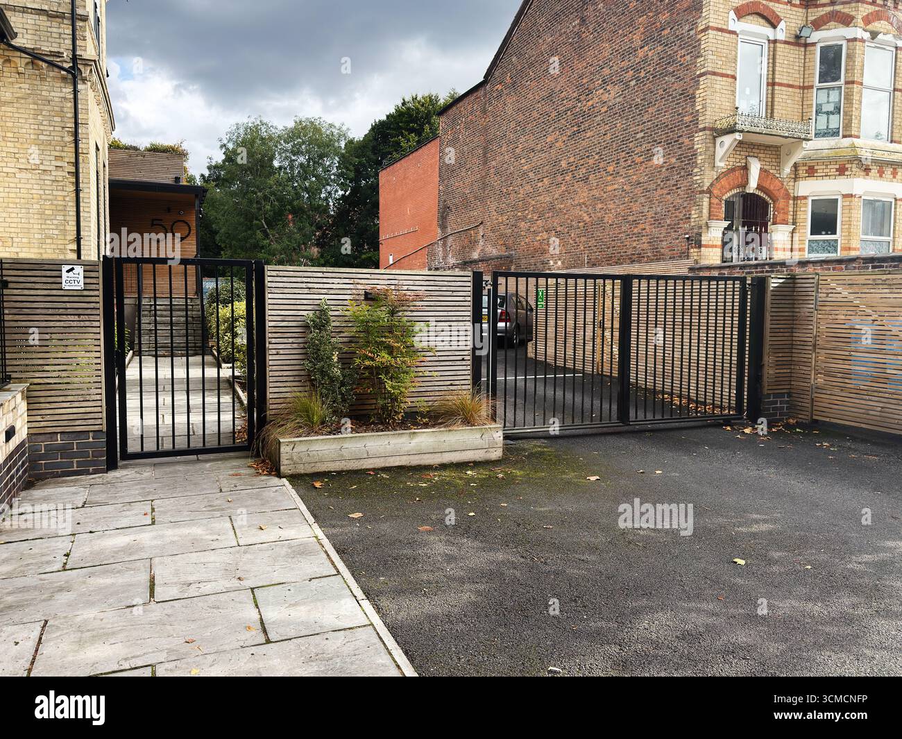 Manchester, Großbritannien - 13. September 2025: Eingangstor zu den Wohnwohnungen in Manchester mit modernem Design und Grün. Stockfoto