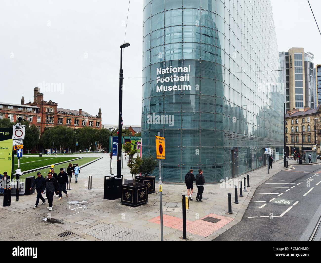 Manchester, Großbritannien - 14. September 2025: Moderne Glasarchitektur des National Football Museum in Manchester, mit Menschen in der Nähe. Stockfoto
