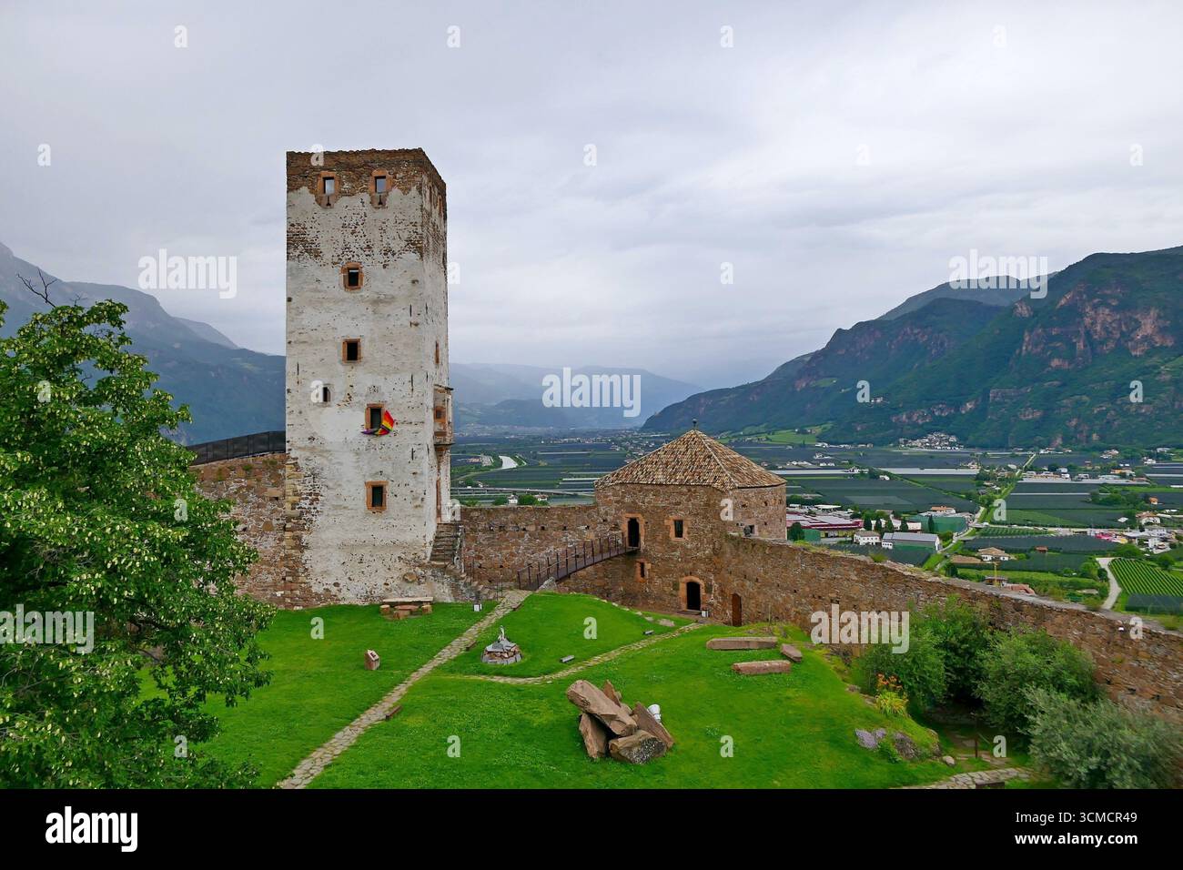 Blick auf den weißen Turm im grünen Innenhof des alten Schlosses Sigmundskron oder Castel Firmiano, ein Symbol der Geschichte Südtirols, Italien Stockfoto
