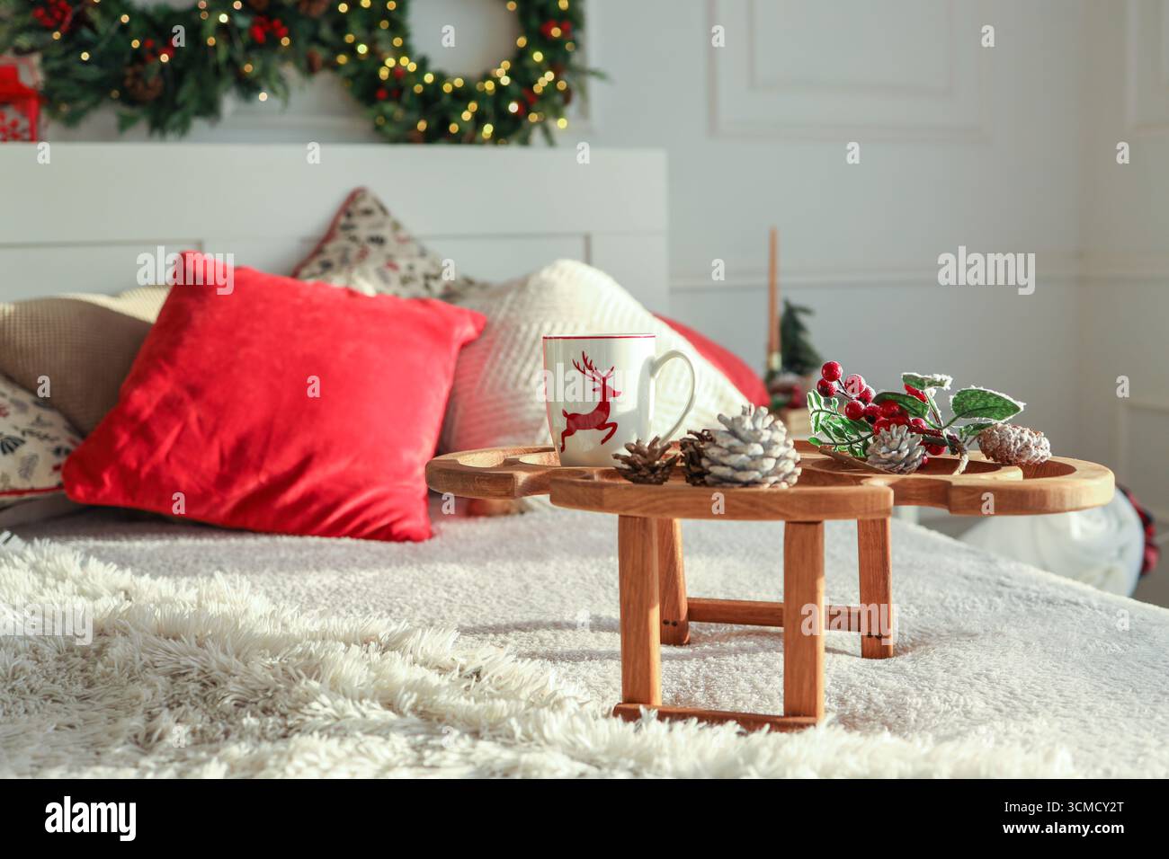 Holztablett mit Frühstück auf dem Bett. Stockfoto