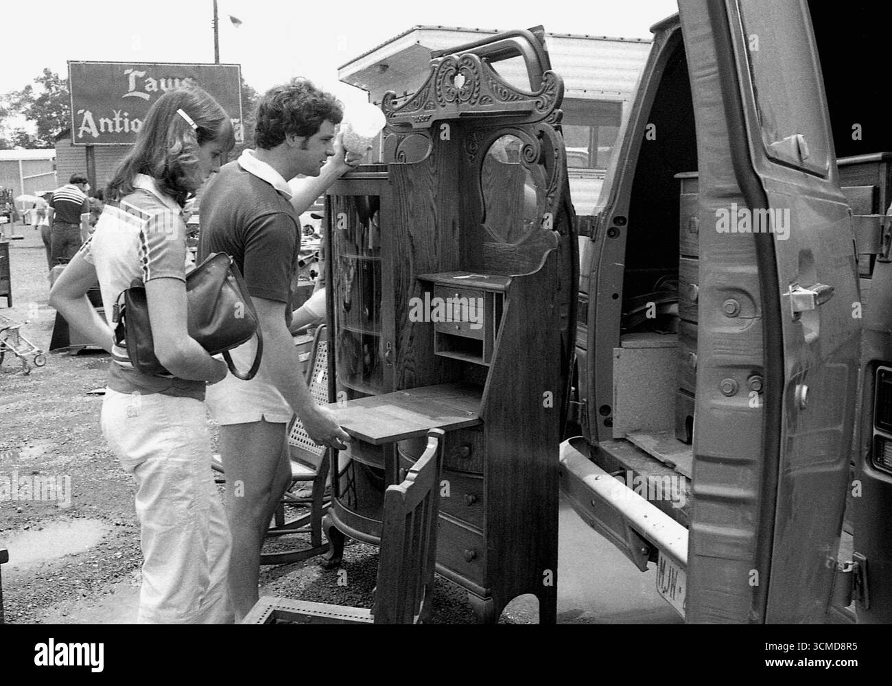 Ein junges Paar, das auf einem Flohmarkt in Connecticut, USA, 1982 alte Möbel ansieht Stockfoto