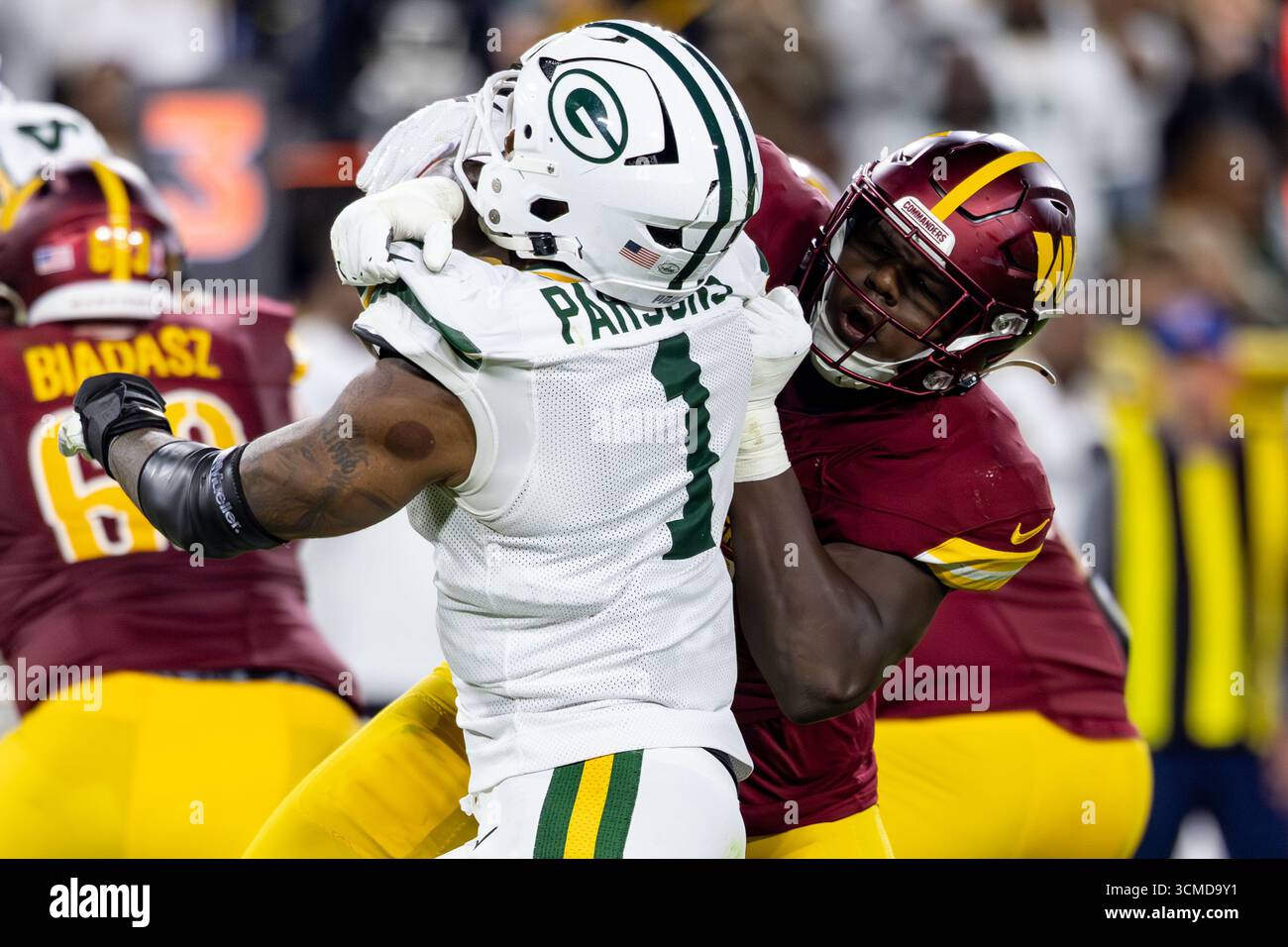 Green Bay, WI, USA; Washington Commanders Defensive Tackle Jer'Zhan Newton (95) blendet Green Bay Packers Defensive End Micah Parsons (1) bei einem Passspiel während eines NFL-Spiels am Donnerstag, den 11. September 2025 im Lambeau Field. Die Packers schlugen die Commanders 28-18. (Alyssa Piazza/Bild des Sports) Stockfoto