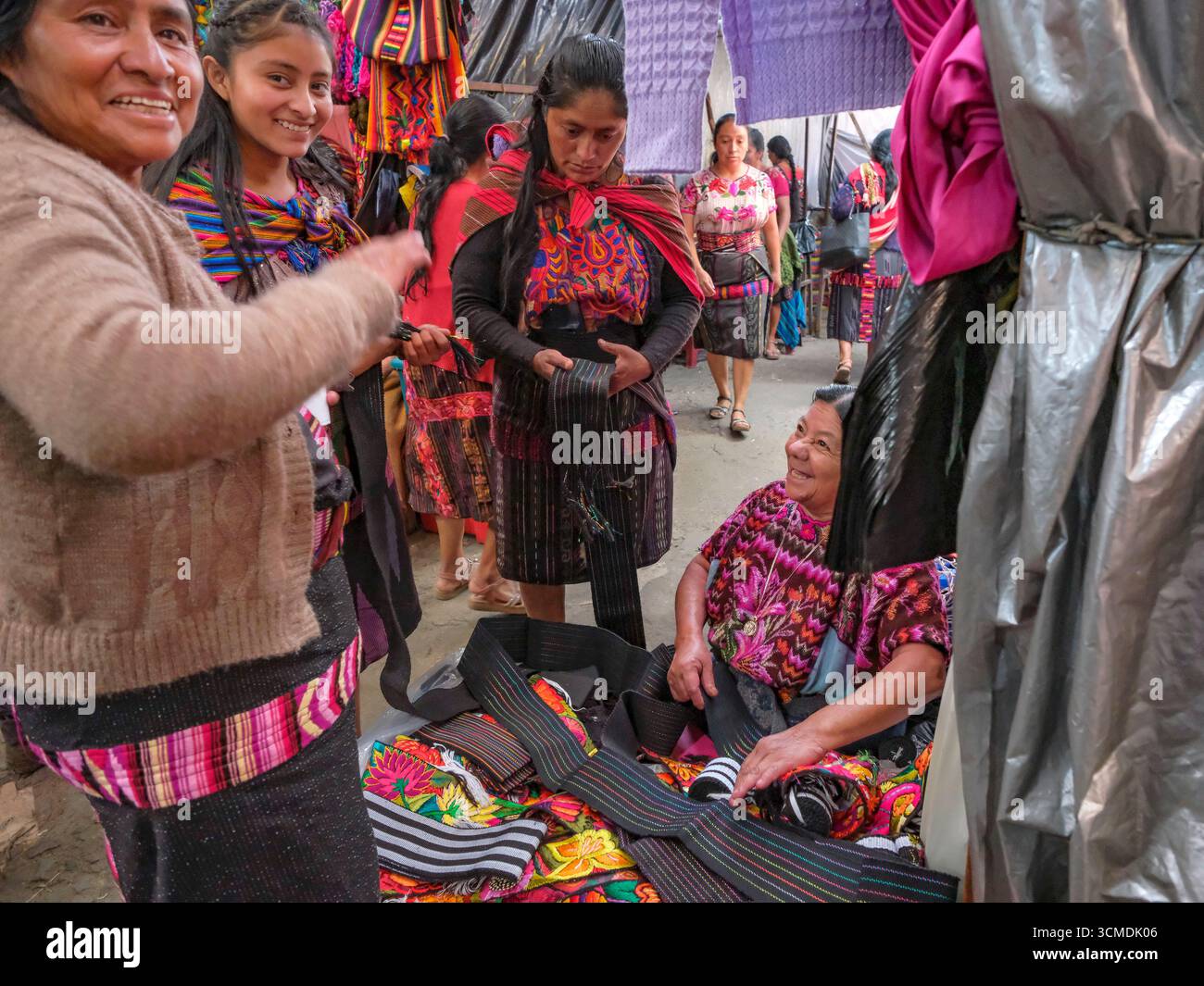 Chichicastenango, Guatemala - 3. Juli 2025: Frauen kaufen traditionelle Kleidung auf dem Santo Tomas Markt in Chichicastenango, Guatemala. Stockfoto