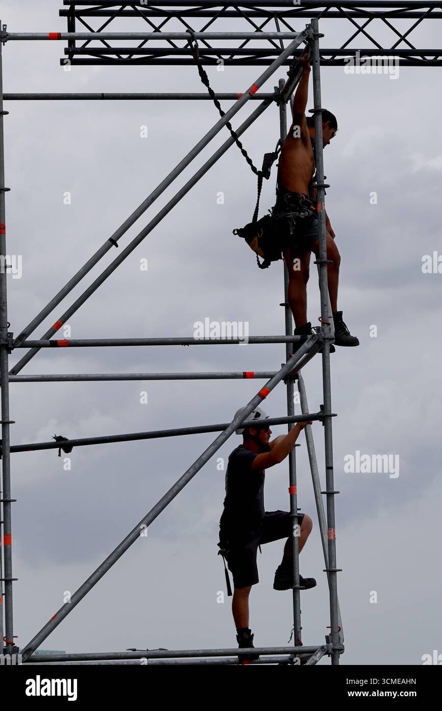 Arbeiter in gut sichtbarer Kleidung demontieren nach Sail 2025 in Amsterdam, Niederlande, temporäre Eventstrukturen, wobei die Besatzung die Verkleidungen abbaut. Stockfoto