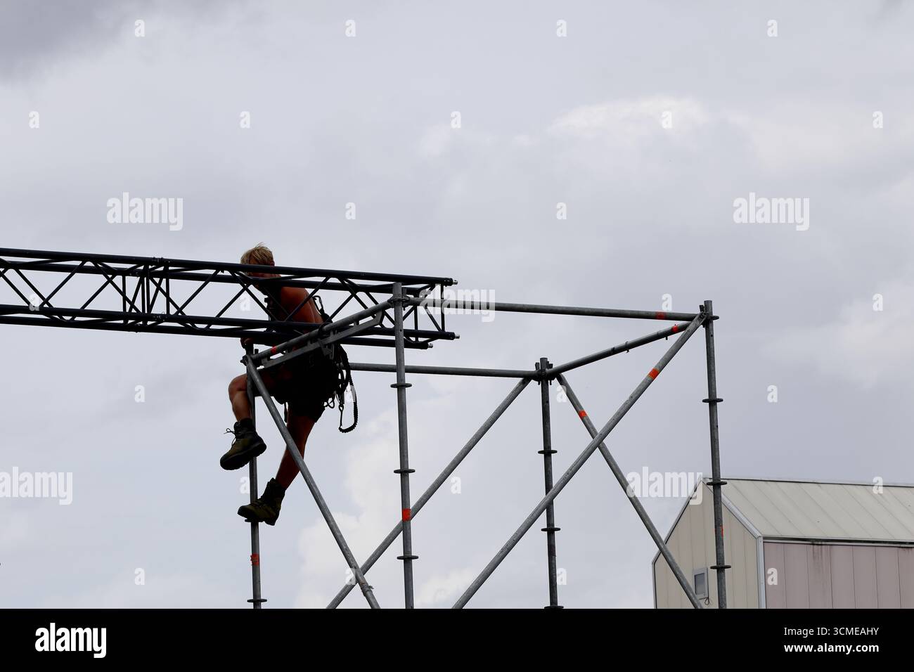 Besatzung in Helmen und Westen unterer Metallabschnitte beim Zerlegen von Installationen nach Sail 2025 in Amsterdam, Niederlande, Teamarbeit auf einer Straße. Stockfoto