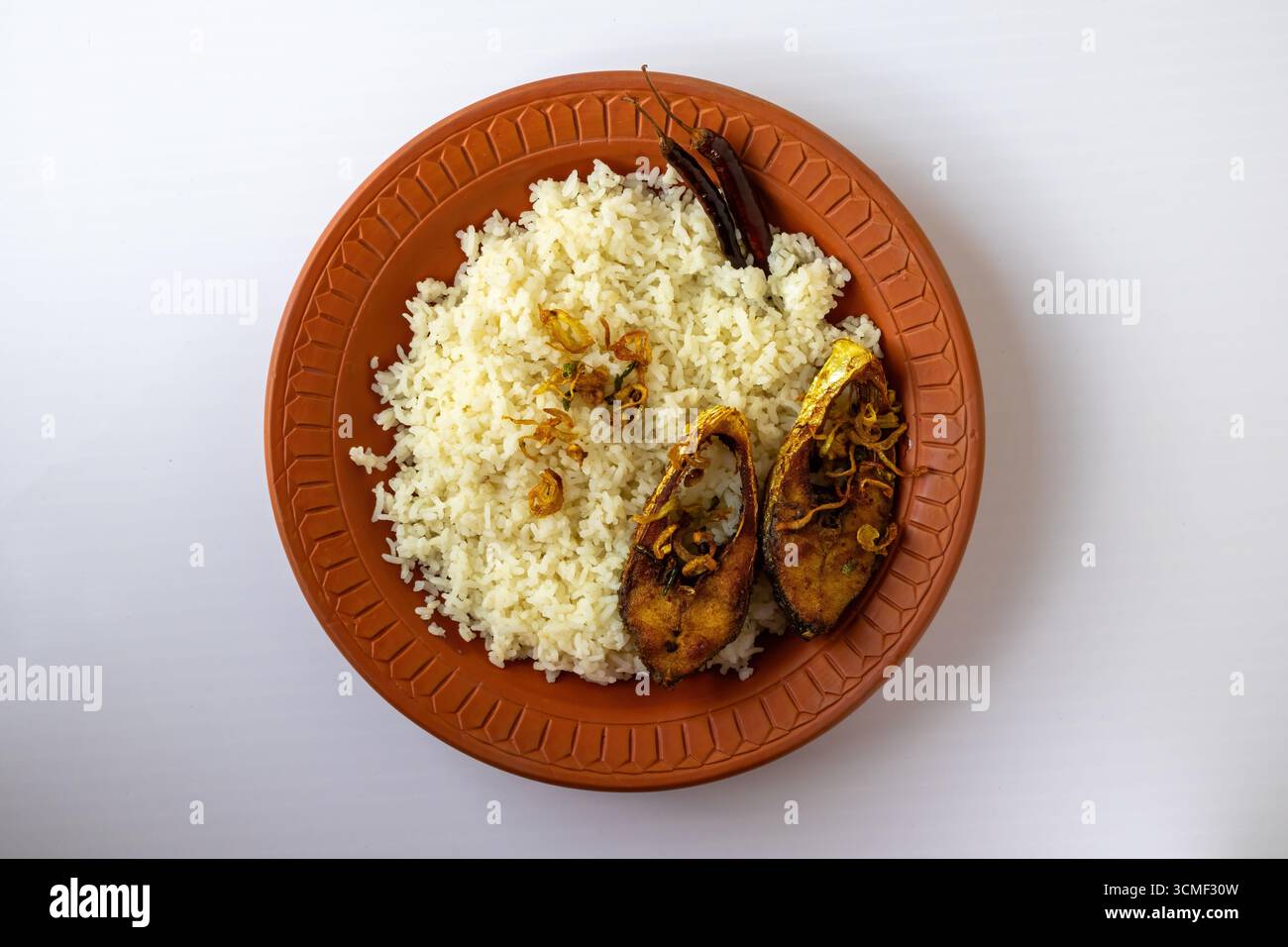 Authentisches Ilish Bhaja und Plain Rice auf einer Tonplatte. Ein Blick von oben auf Bangladeschs beliebtestes Fischgericht, Hilsha Fry, betont die traditionelle Küche Stockfoto